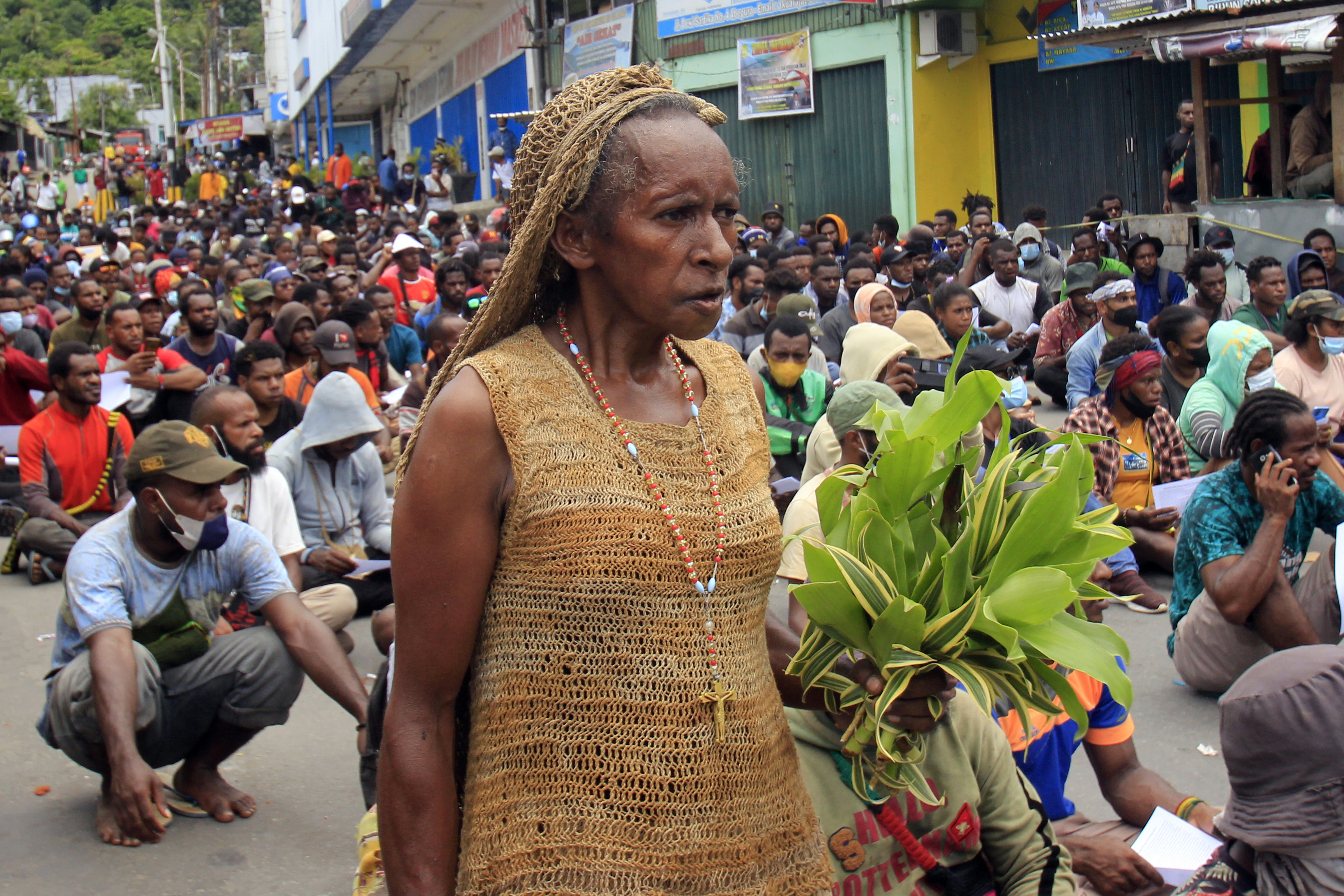  Warga melintasi ratusan mahasiwa yang mengikuti aksi penolakan pemekaran Papua  di Lingkaran Abe, Distrik Abepura, Kota Jayapura, Papua.