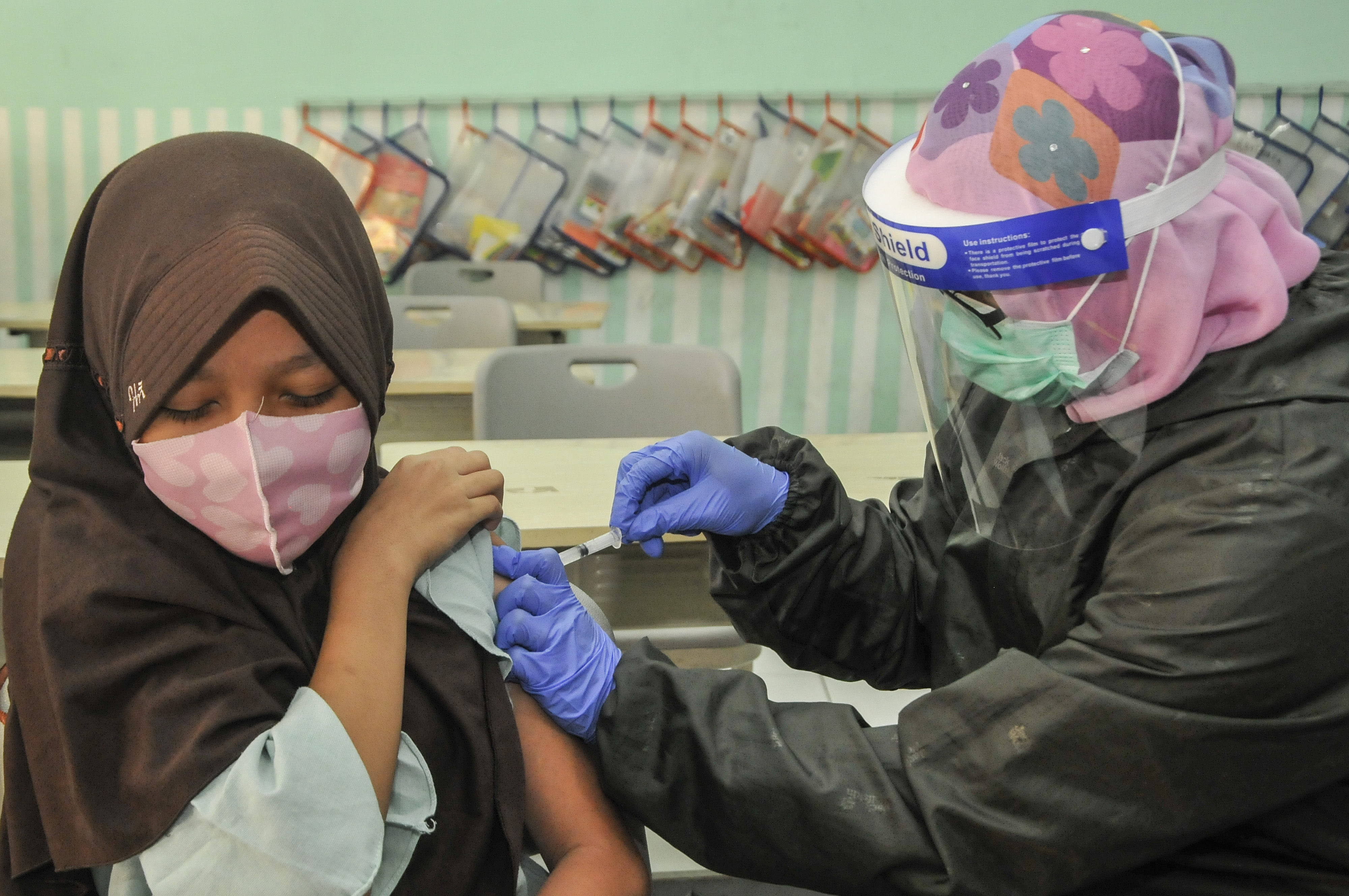 Nakes menyuntikkan vaksin HPV kepada siswi Sekolah Dasar Negeri (SDN) 05 pada kegiatan bulan imunisasi di Pondok Kelapa, Jakarta Timur.