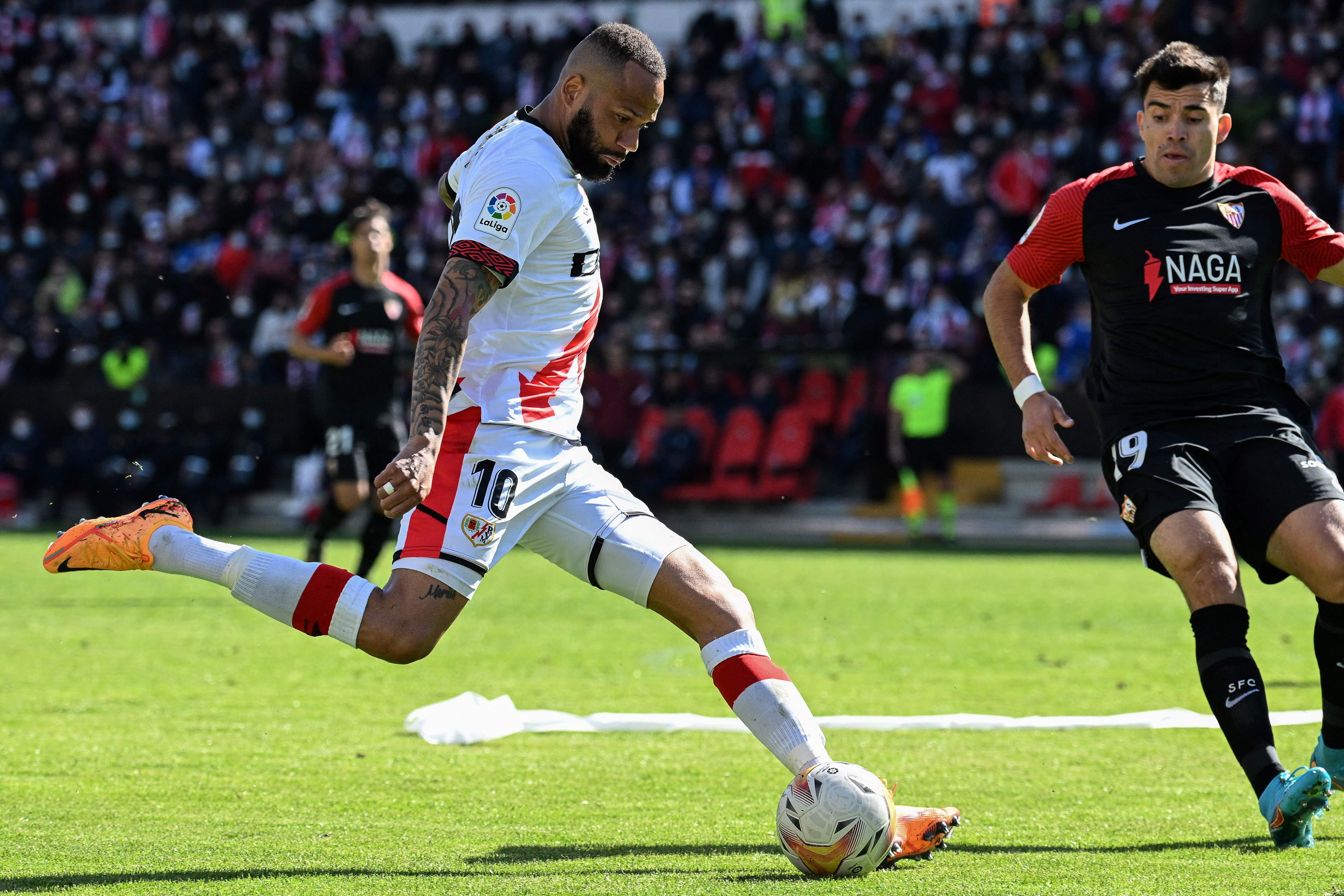 Pemain Rayo Vallecano berusaha menendang bola di hadapan pemain Sevilla FC.