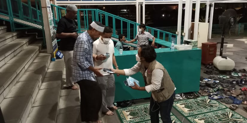 Petugas BNPB membagikan masker kepada warga di sejumlah lokasi strategis.