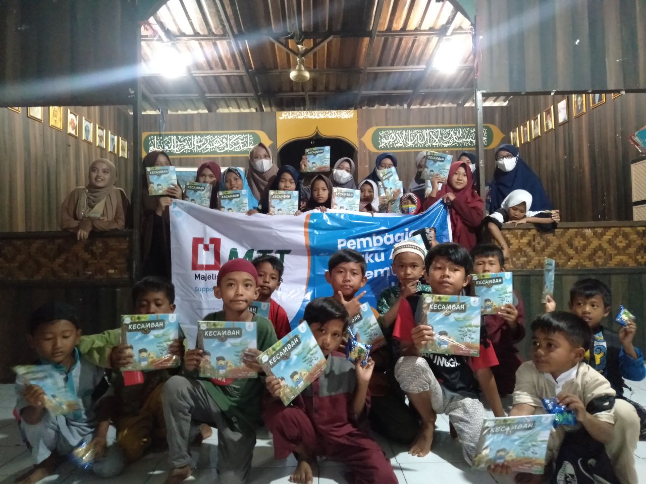 Anak-anak menerima buku bacaan dari Rumah Amal Salman