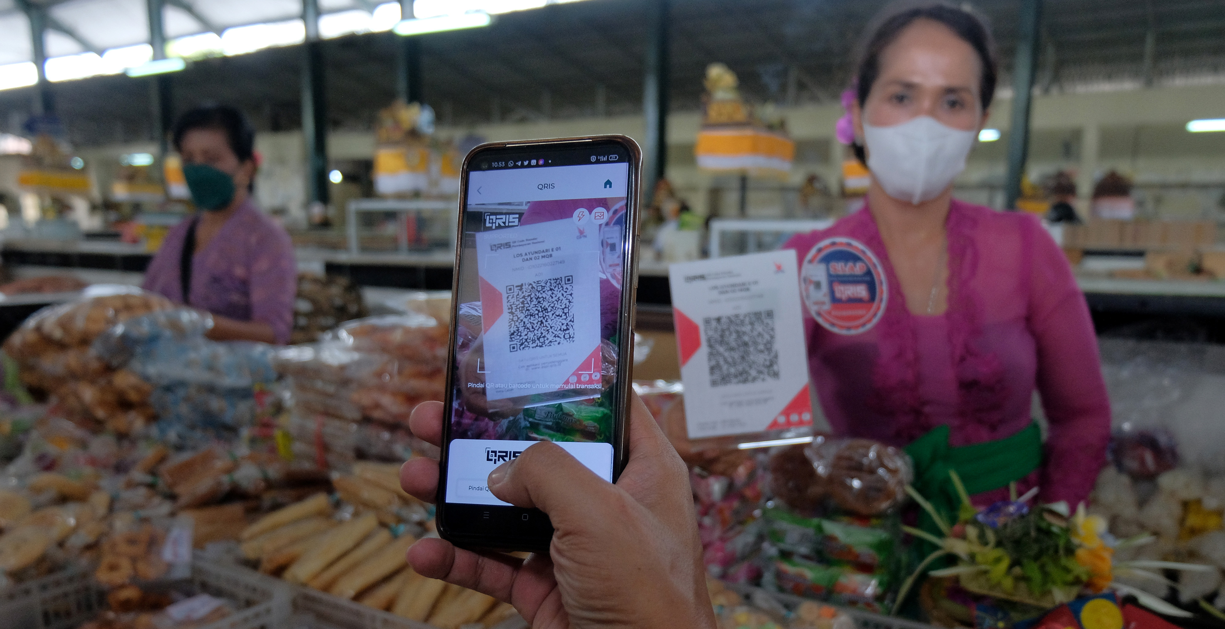 Ilustrasi: Warga melakukan pembayaran menggunakan fitur pemindai QRIS di Pasar Nyanggelan, Bali