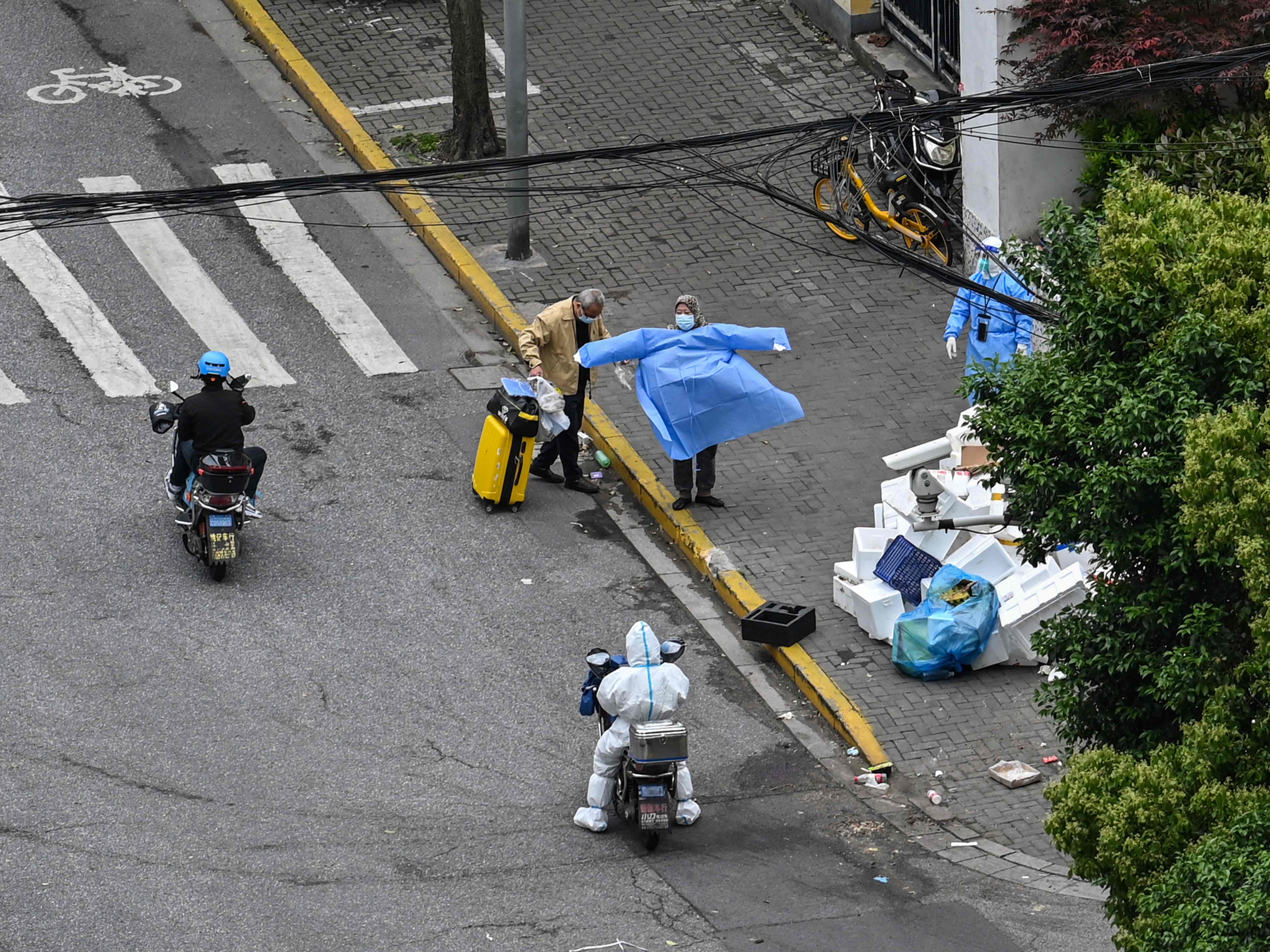 Warga sekitar menunggu bus selama penguncian covid-19 di distrik Jing'an di Shanghai pada 24 April 2022. 