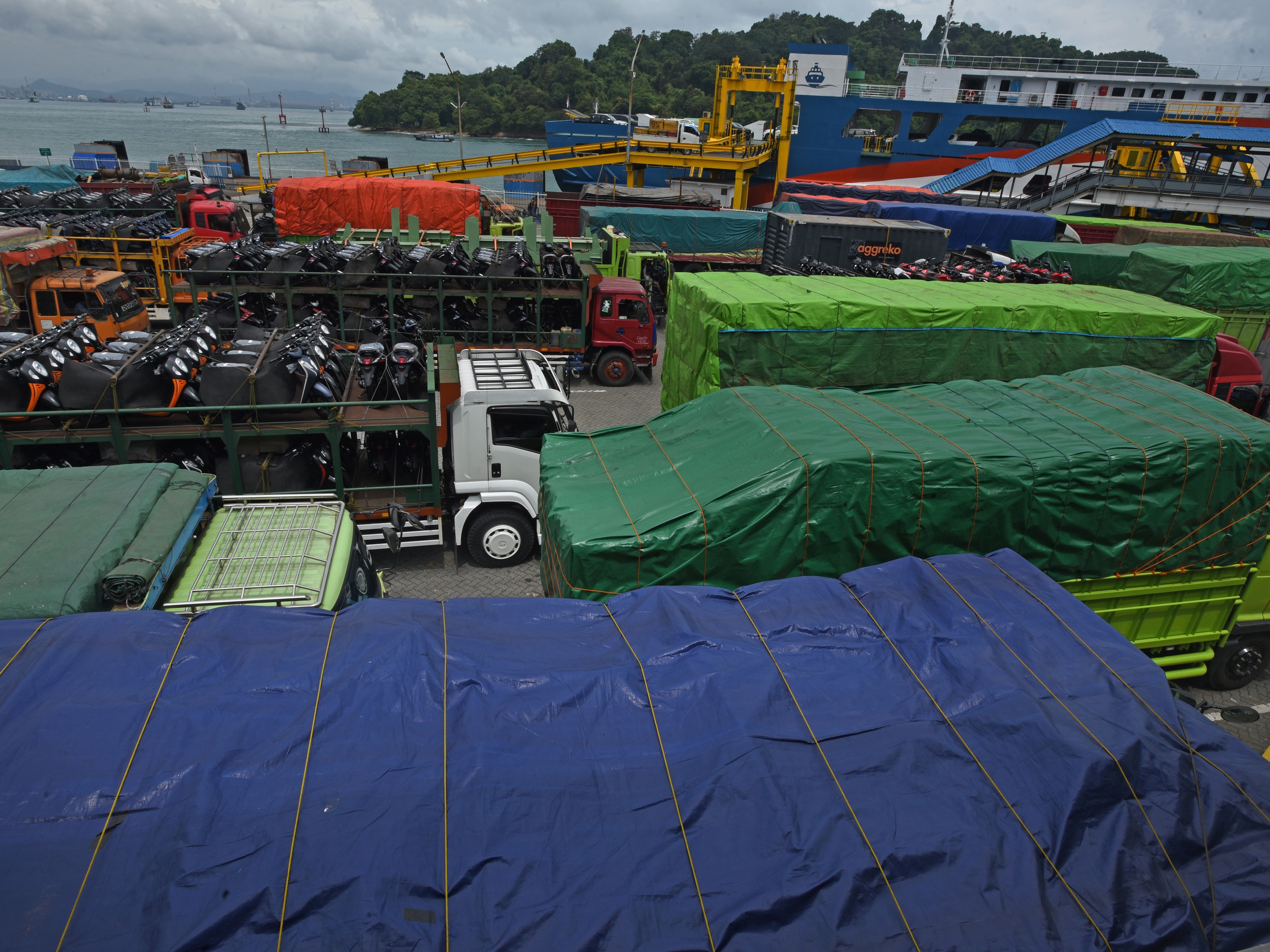Sejumlah truk yang akan menyeberang ke Pulau Sumatra memadati area Dermaga III, Pelabuhan Merak, Cilegon, Banten, Rabu (20/4/2022).