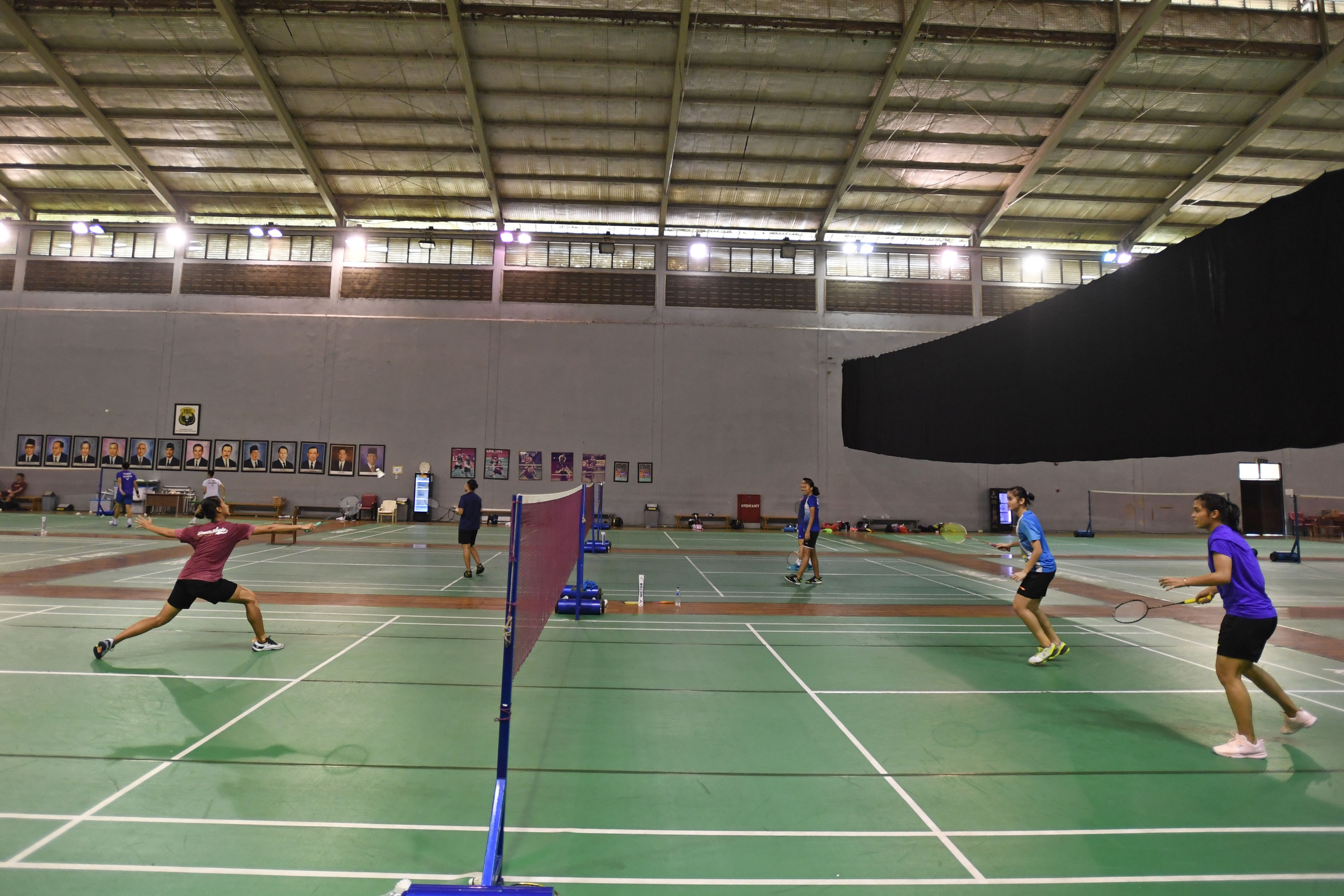 Ilustrasi sejumlah pebulu tangkis sedang berlatih