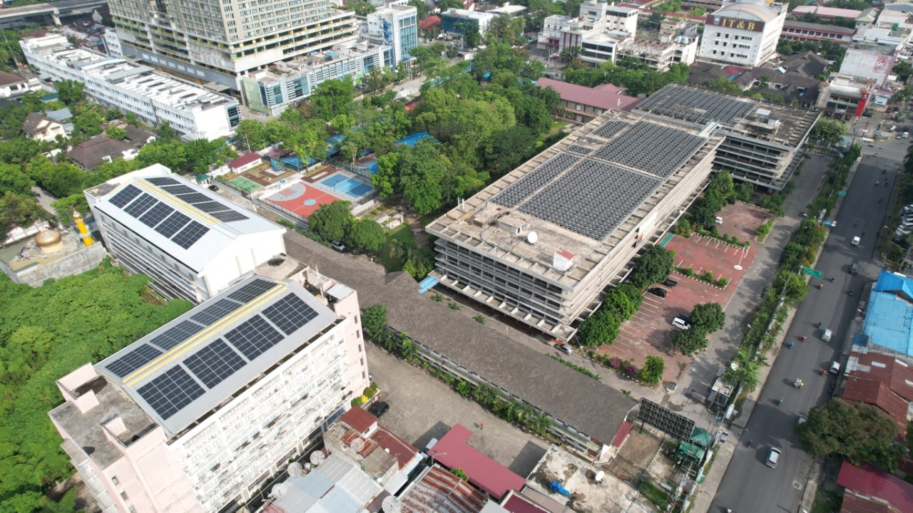 Foto dari udara tampak PLTS Atap yang terpasang di atas Gedung Universitas HKBP Nommensen Medan, Sumatra Utara.
