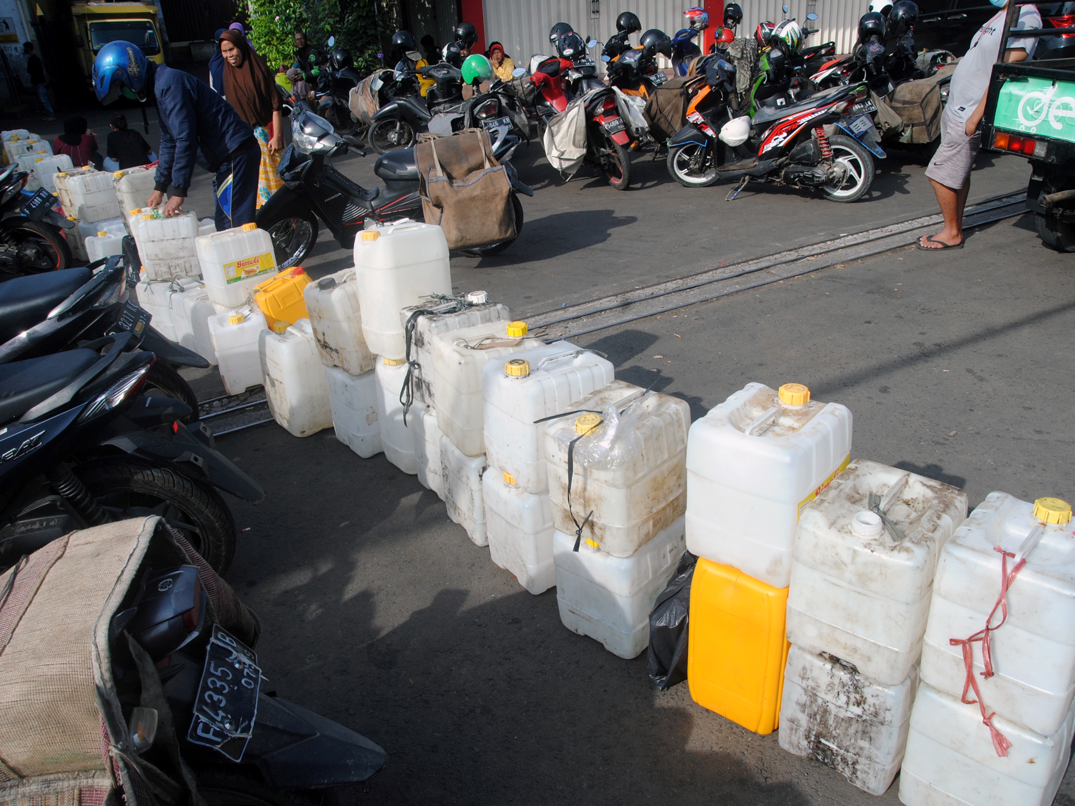 Warga menaruh jeriken saat antre membeli minyak goreng curah di distributor minyak goreng curah, Sindangbarang, Bogor, Selasa (5/4/).