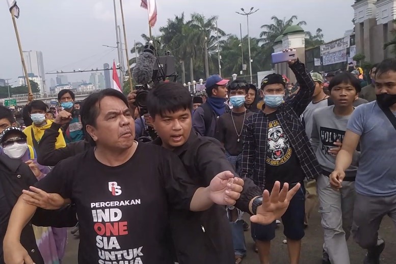 Tangkapan layar video yang menggambarkan Ade Armando saat berada di tengah kerumunan massa sesaat sebelum terjadinya pengeroyokan.