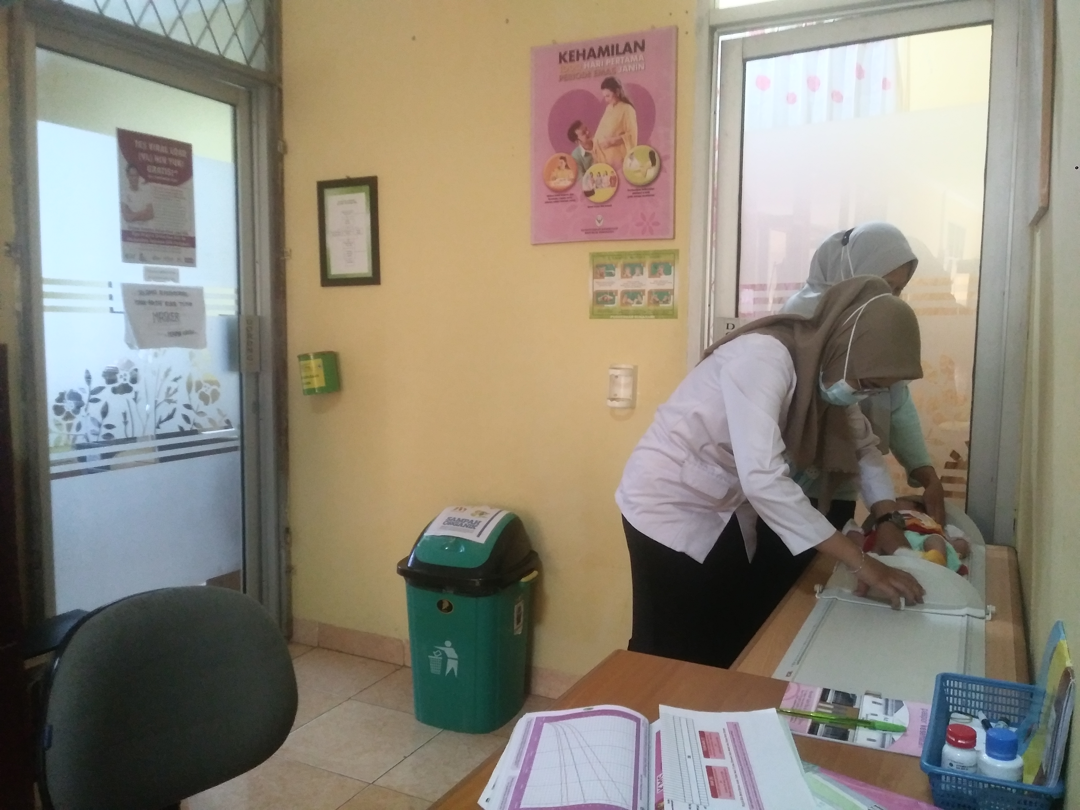 Bidan di puskesmas tengah memeriksa kondisi kesehatan balita