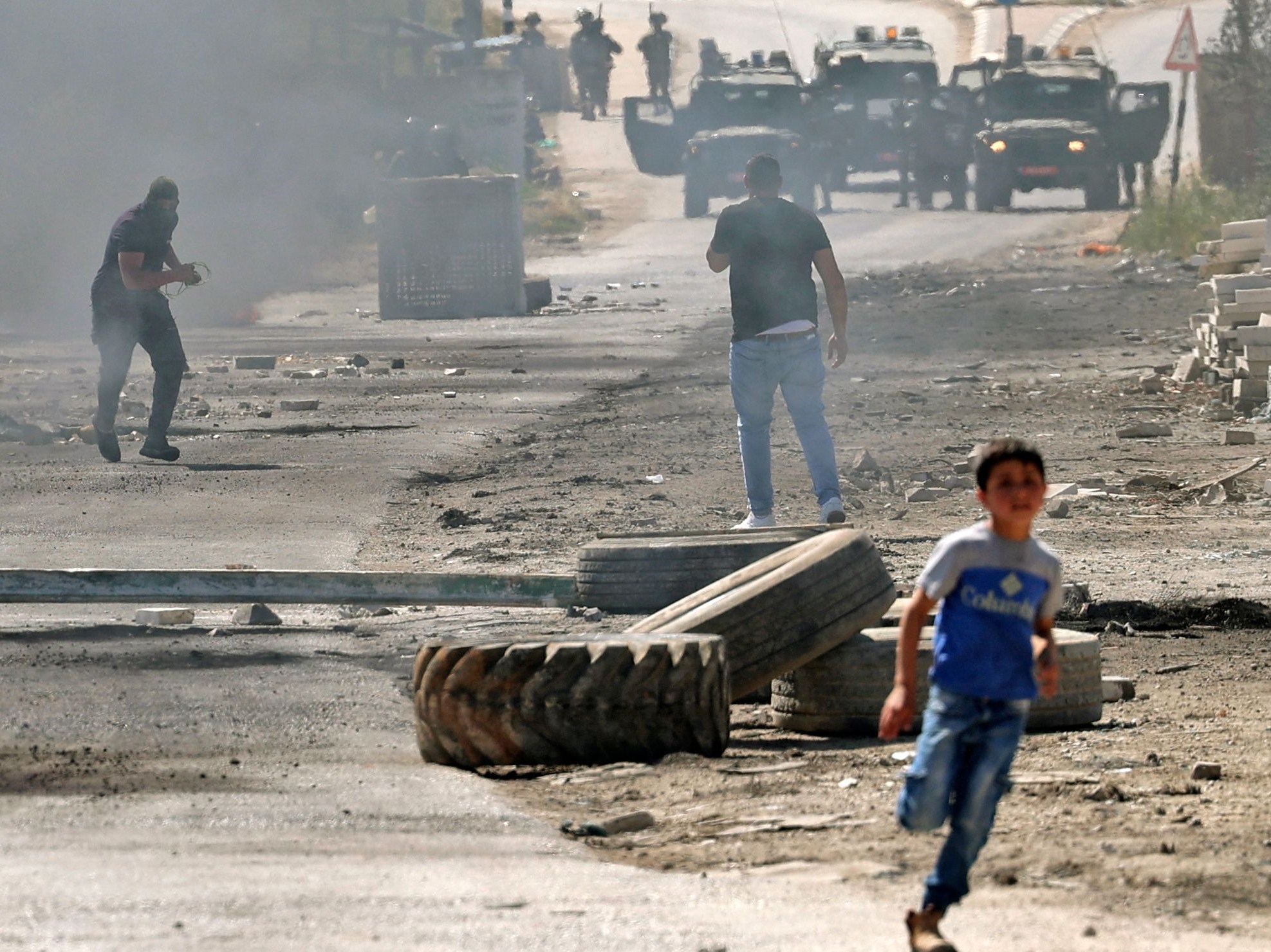 Pengunjuk rasa Palestina mundur diserang gas air mata selama bentrokan dengan pasukan keamanan Israel, Desa Beita, Tepi Barat, Jumat (15/4).