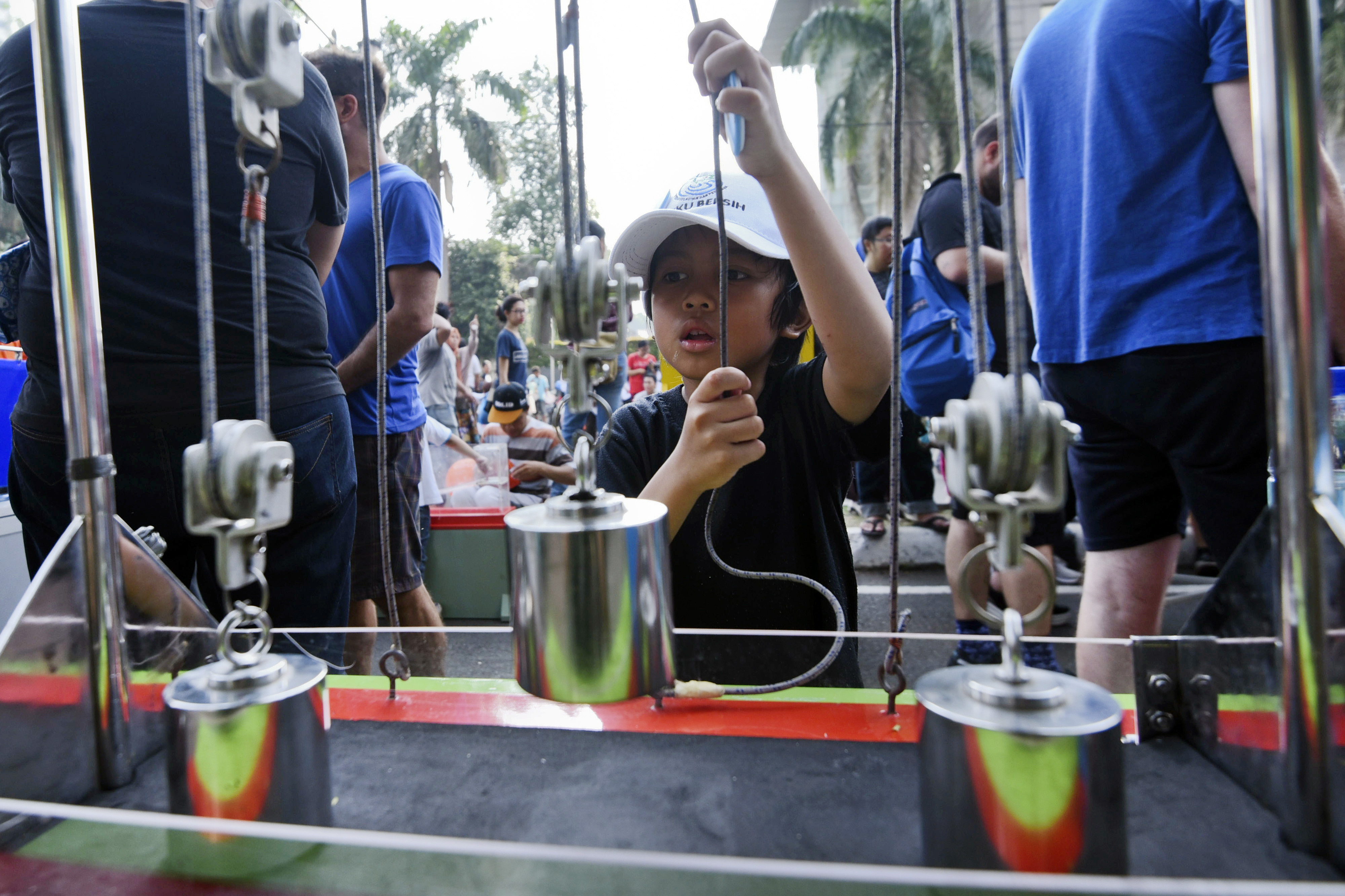 Seorang anak mencoba alat peraga yang disediakan oleh Indonesia Science Center atau biasa dikenal dengan Pusat Peragaan Iptek BRIN.