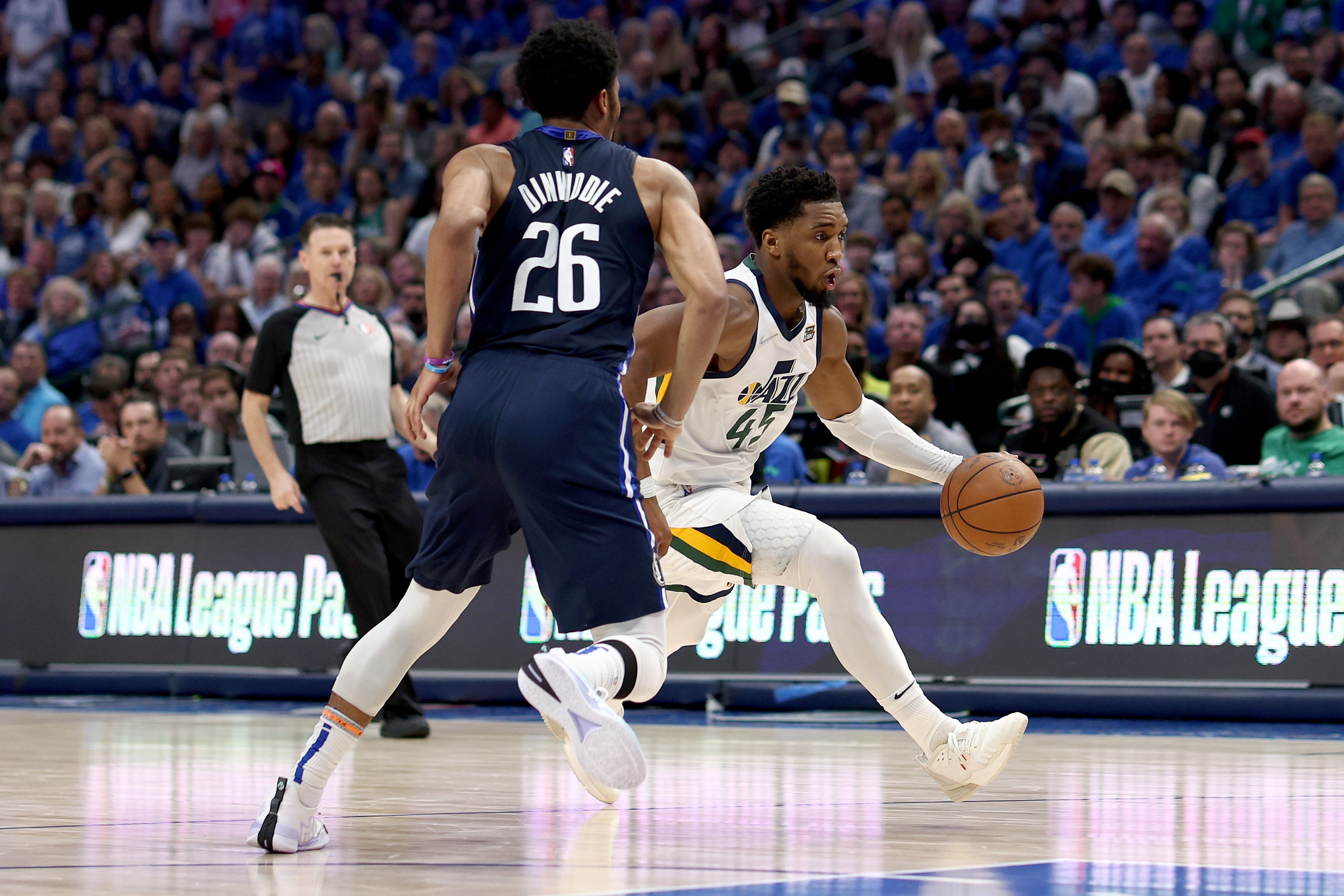 Pemain Utah Jazz, Donovan Mitchell (kanan), menggiring boia, sementara Spencer Dinwiddie dari Dallas Mavericks berusaha untuk membendung.