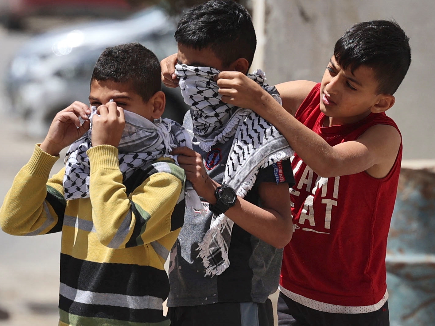 Anak-anak Palestina digambarkan mengenakan Kefiyeh kotak-kotak untuk menutupi wajah mereka di kota Jenin, Tepi Barat yang dijajah.