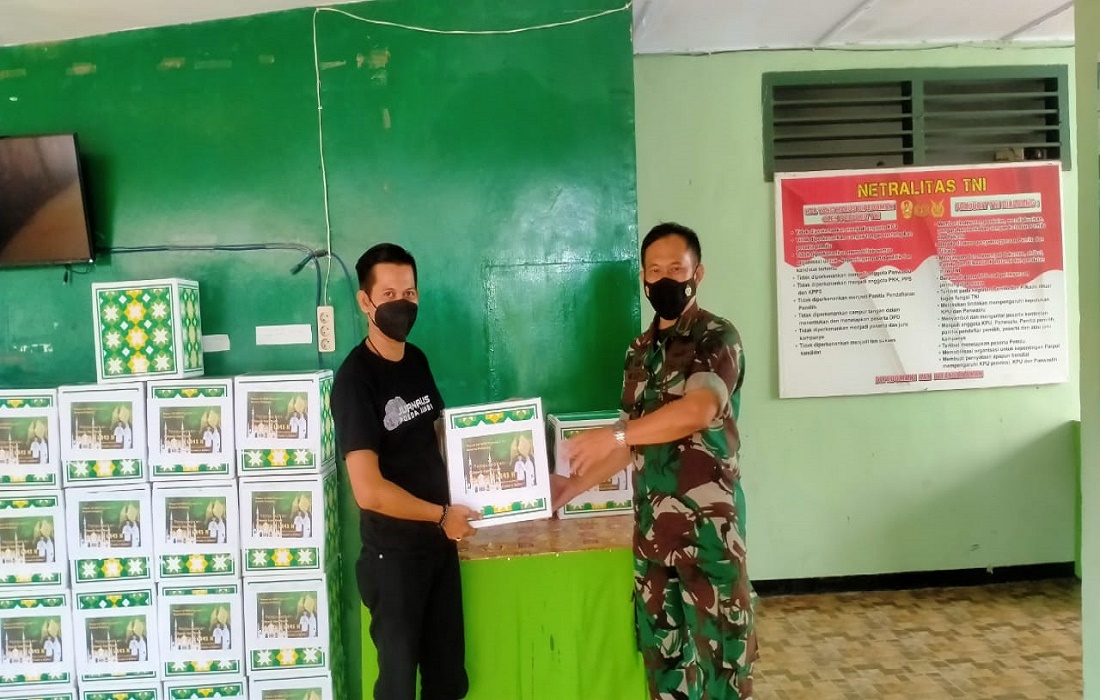 Komandan Koramil Telanaipura, Jambi,  Mayor Inf Widi Purwoko menyerahkan bingkisan kepada seorang wartawan