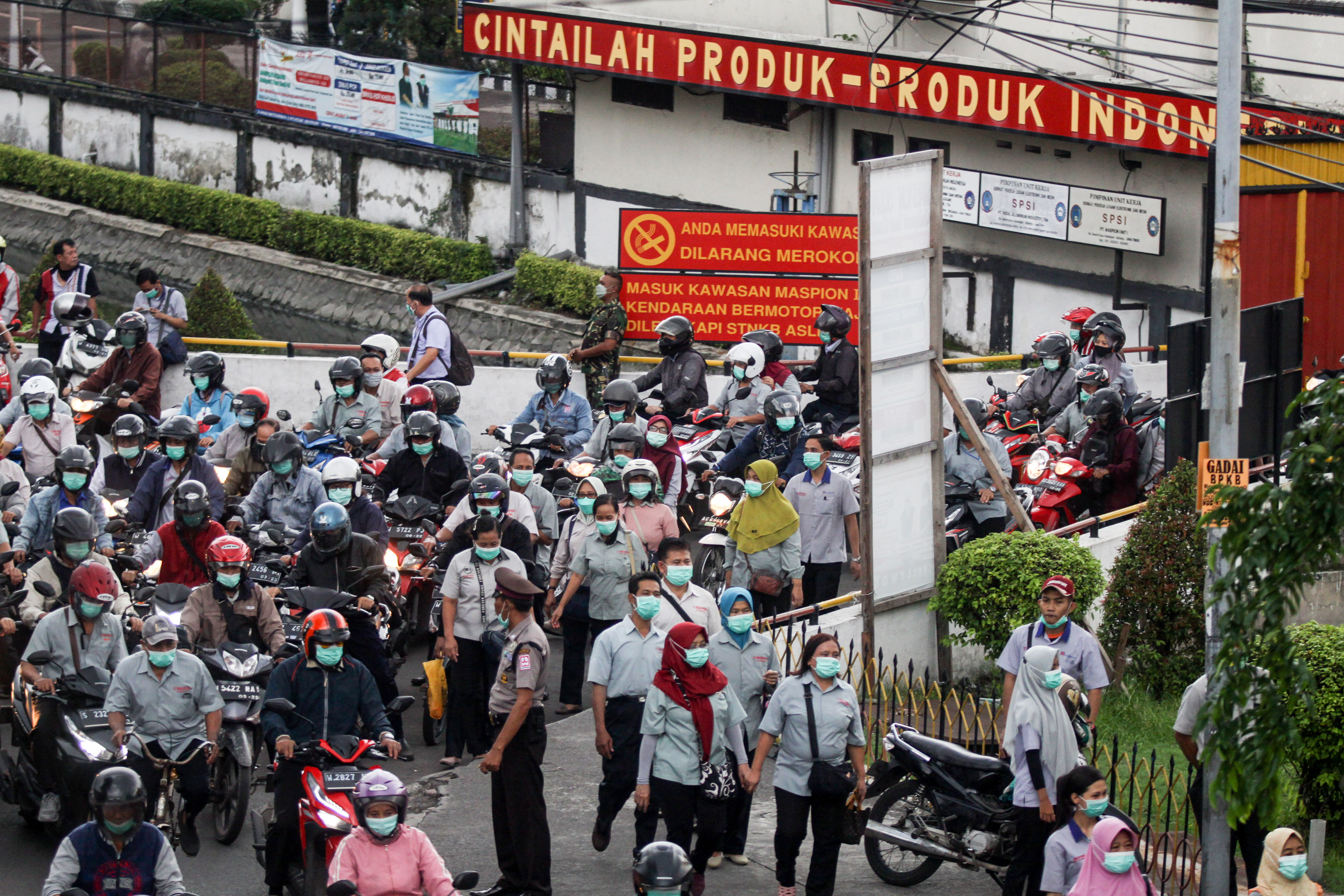 Sejumlah buruh keluar dari pabrik kawasan Sidoarjo, Jawa Timur, saat jam pulang kerja.