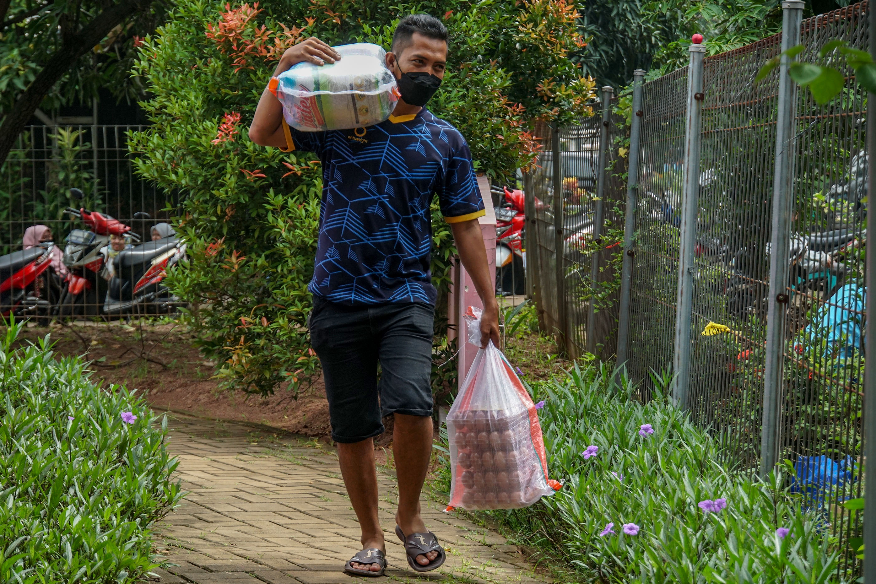 Warga membawa bahan pangan bersubsidi usai membelinya di RPTRA Ria Damkar Joglo 2