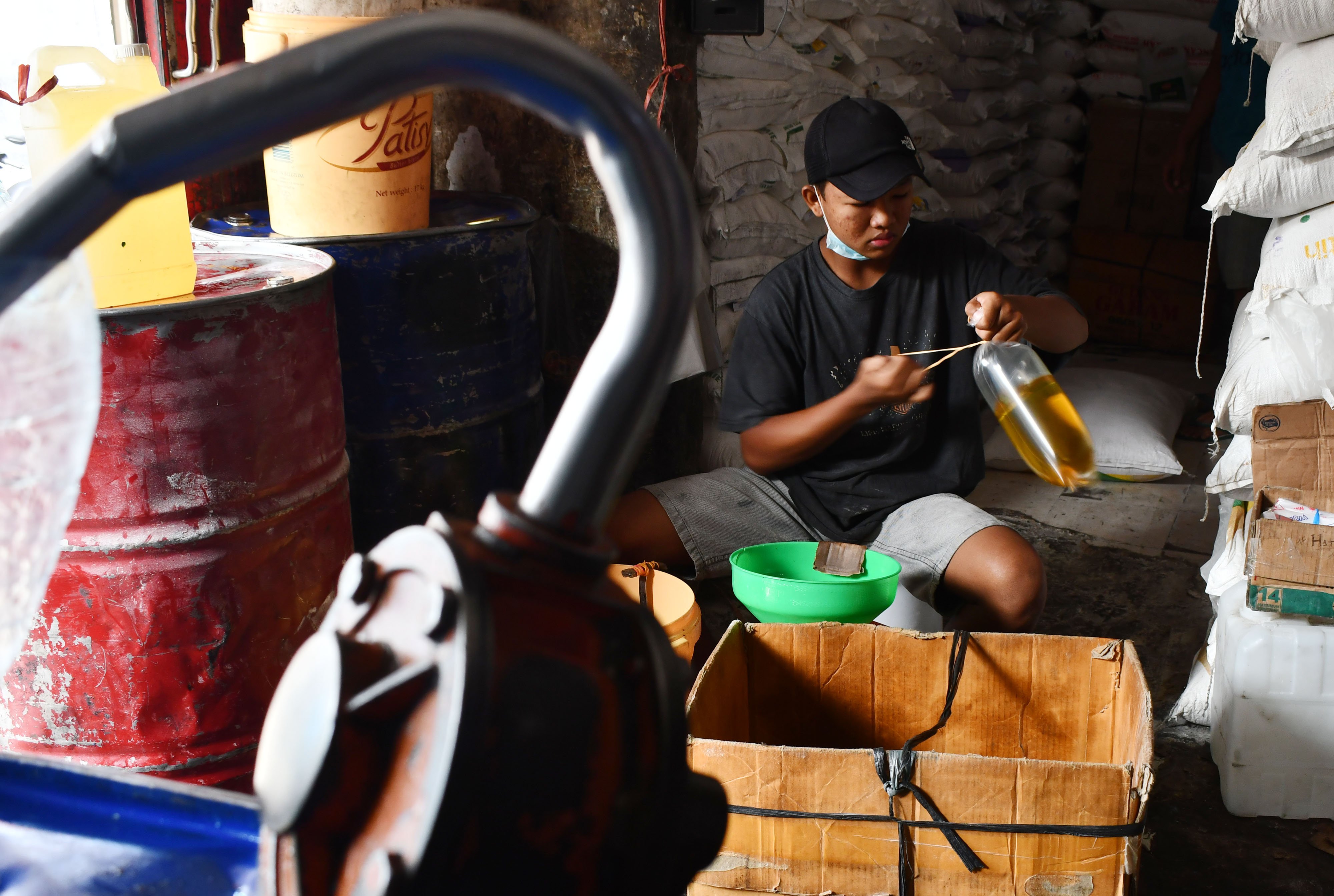 Pedagang mengemas minyak goreng curah