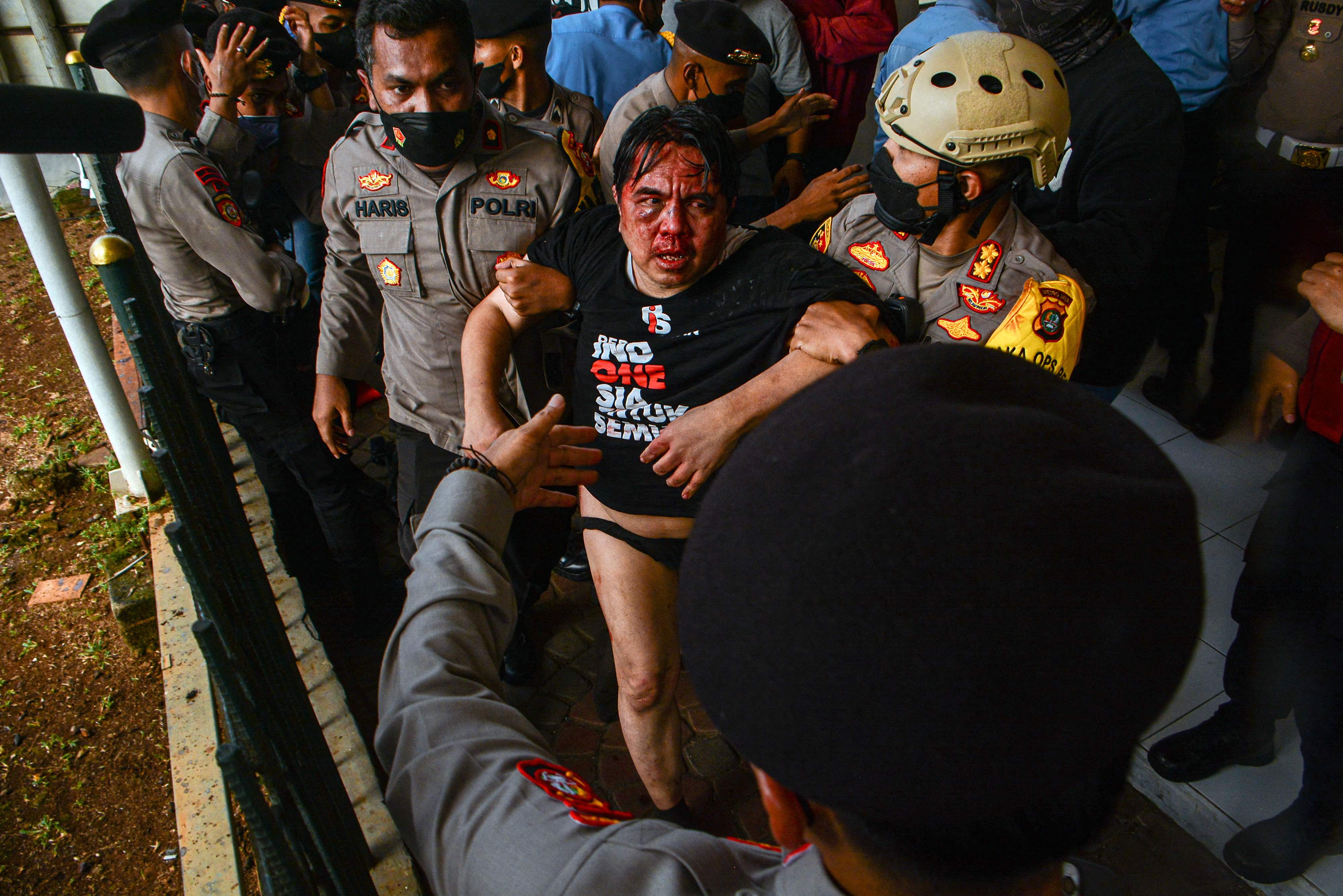 Polsi membantu Ade Armando yang menjadi korban pengoyokan saat aksi demonstrasi, Senin (11/4).