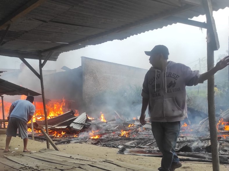 Warga berusaha memadamkan kobaran api.