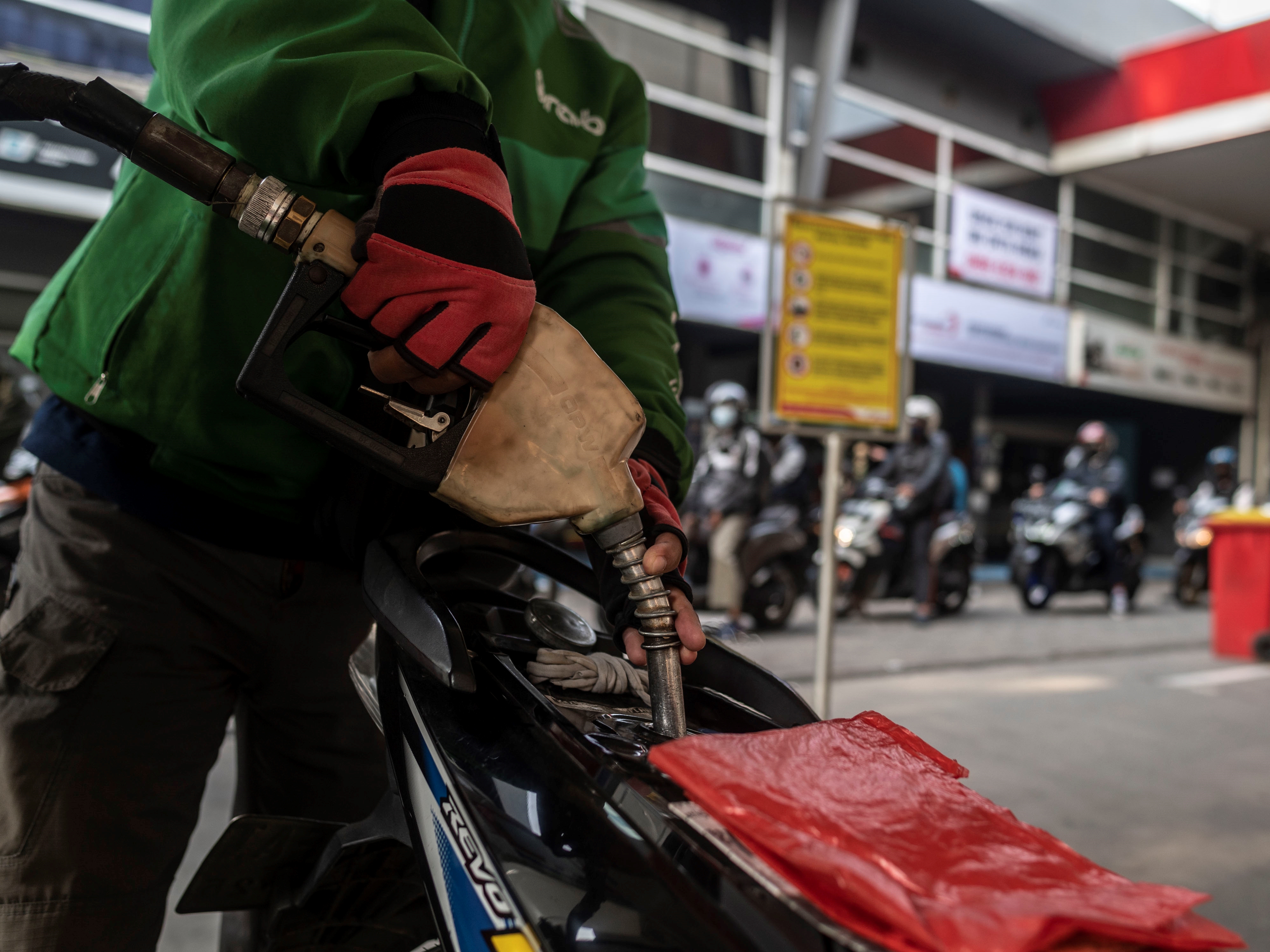 Warga mengisi bahan bakar minyak (BBM) jenis pertalite ke sepeda motornya di SPBU Kuningan, Jakarta, Rabu (30/3/2022). 