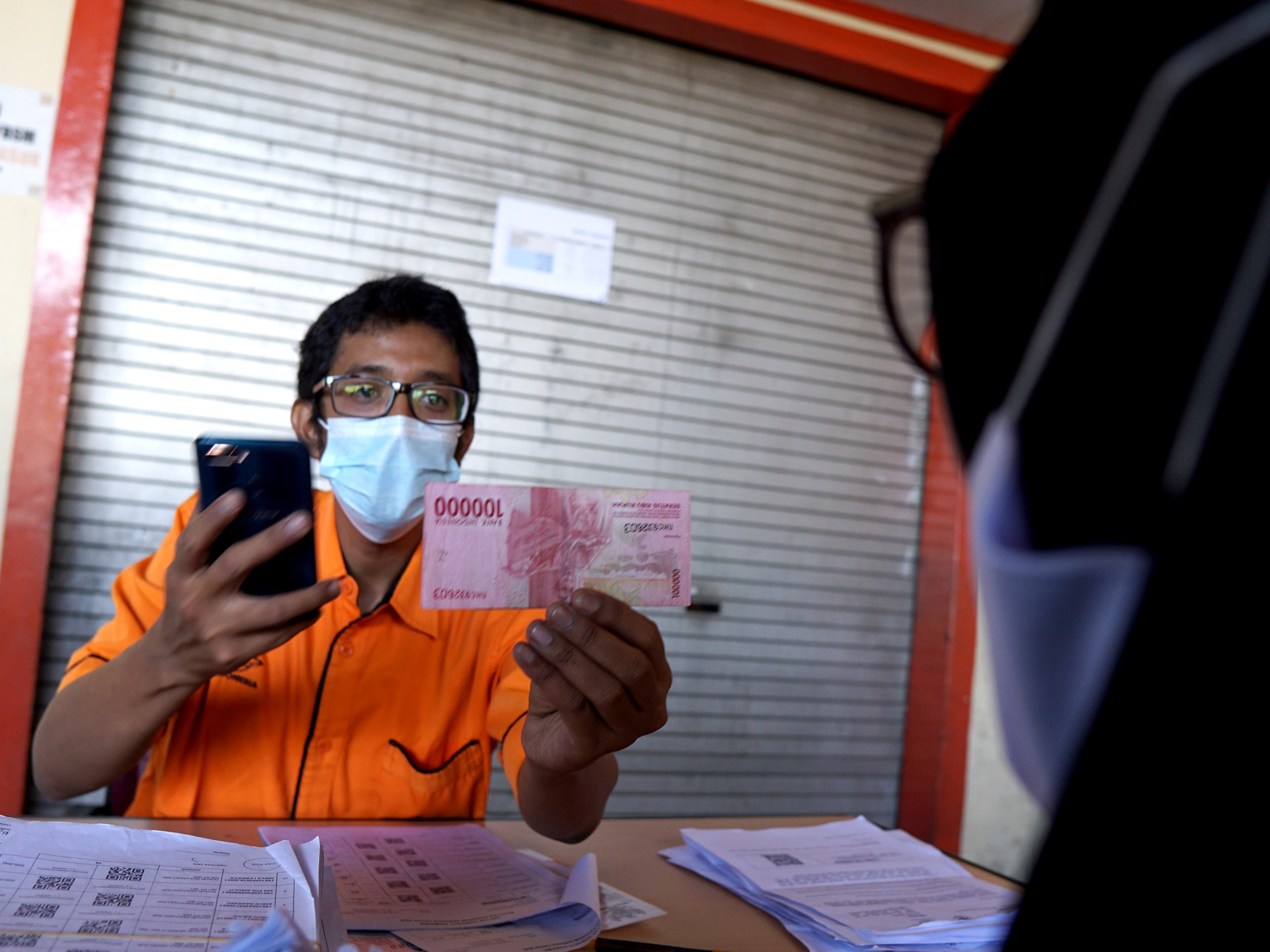 Seorang juru bayar melayani warga penerima BLT subsidi minyak goreng di Kantor Pos, Kota Gorontalo, Gorontalo, Selasa (19/4/2022).