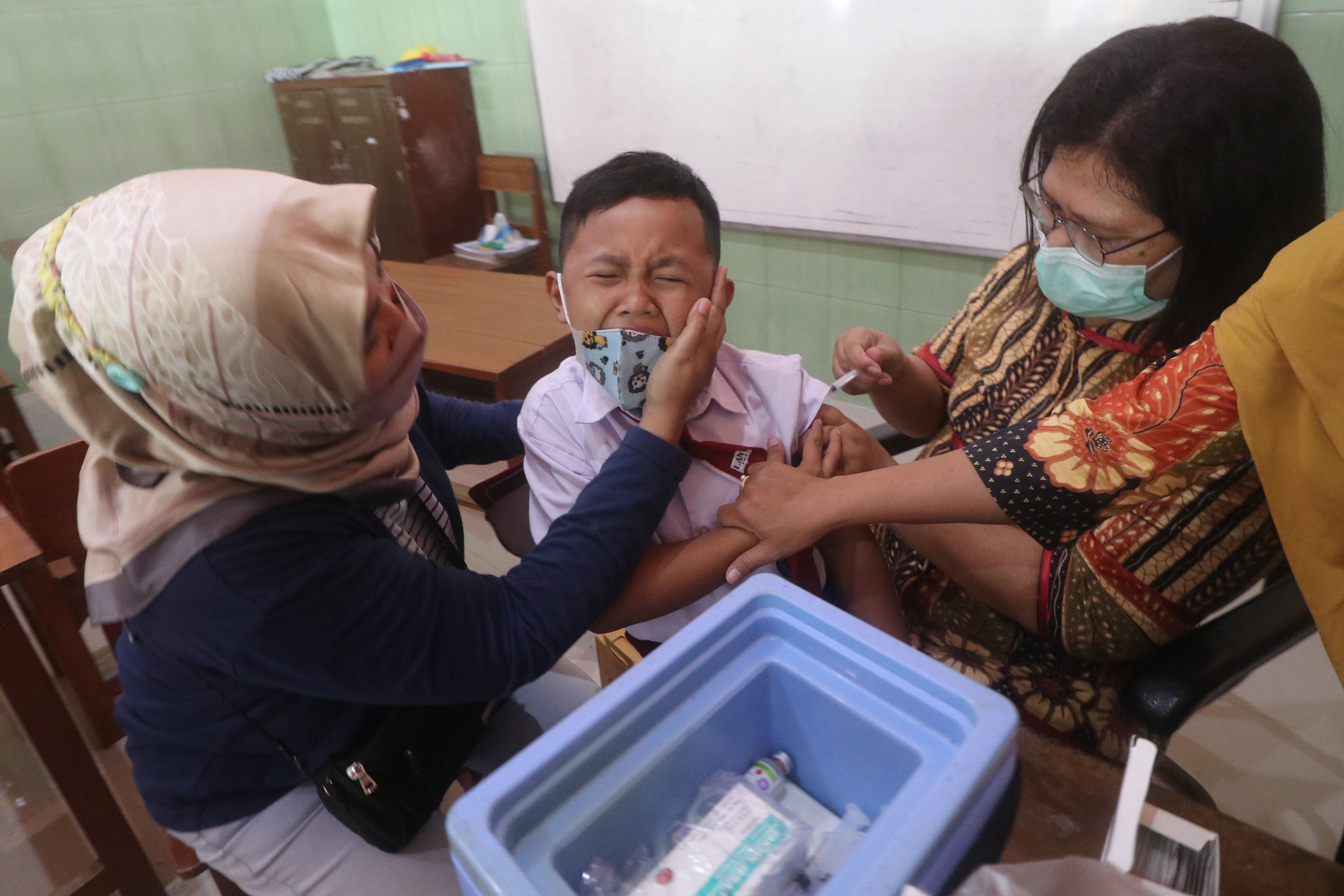 Petugas kesehatan menyuntikkan vaksin Measles and Rubella (MR) lanjutan kepada murid SDN Mojoroto 3 di Kota Kediri, Jawa Timur.