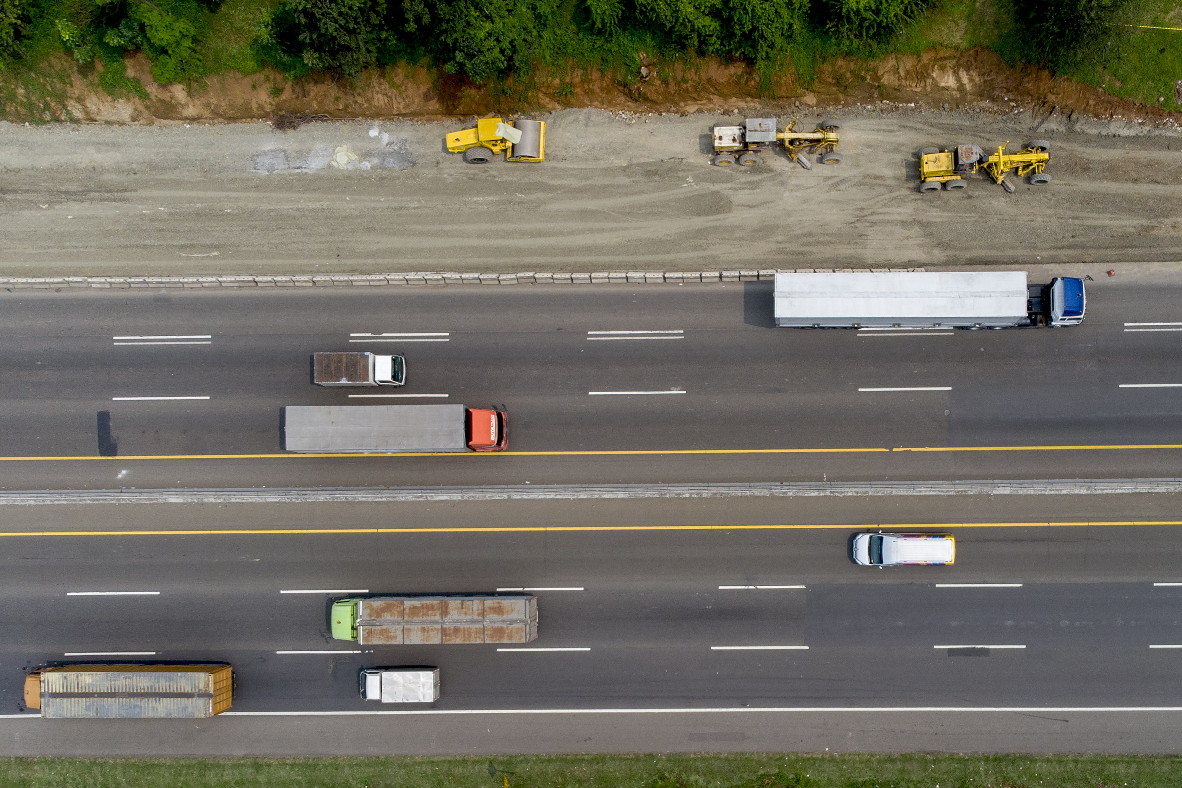 Foto udara pekerja mengoperasikan alat berat saat menyelesaikan proyek pelebaran jalan tol Jakarta-Cikampek di Karawang, Jawa Barat.