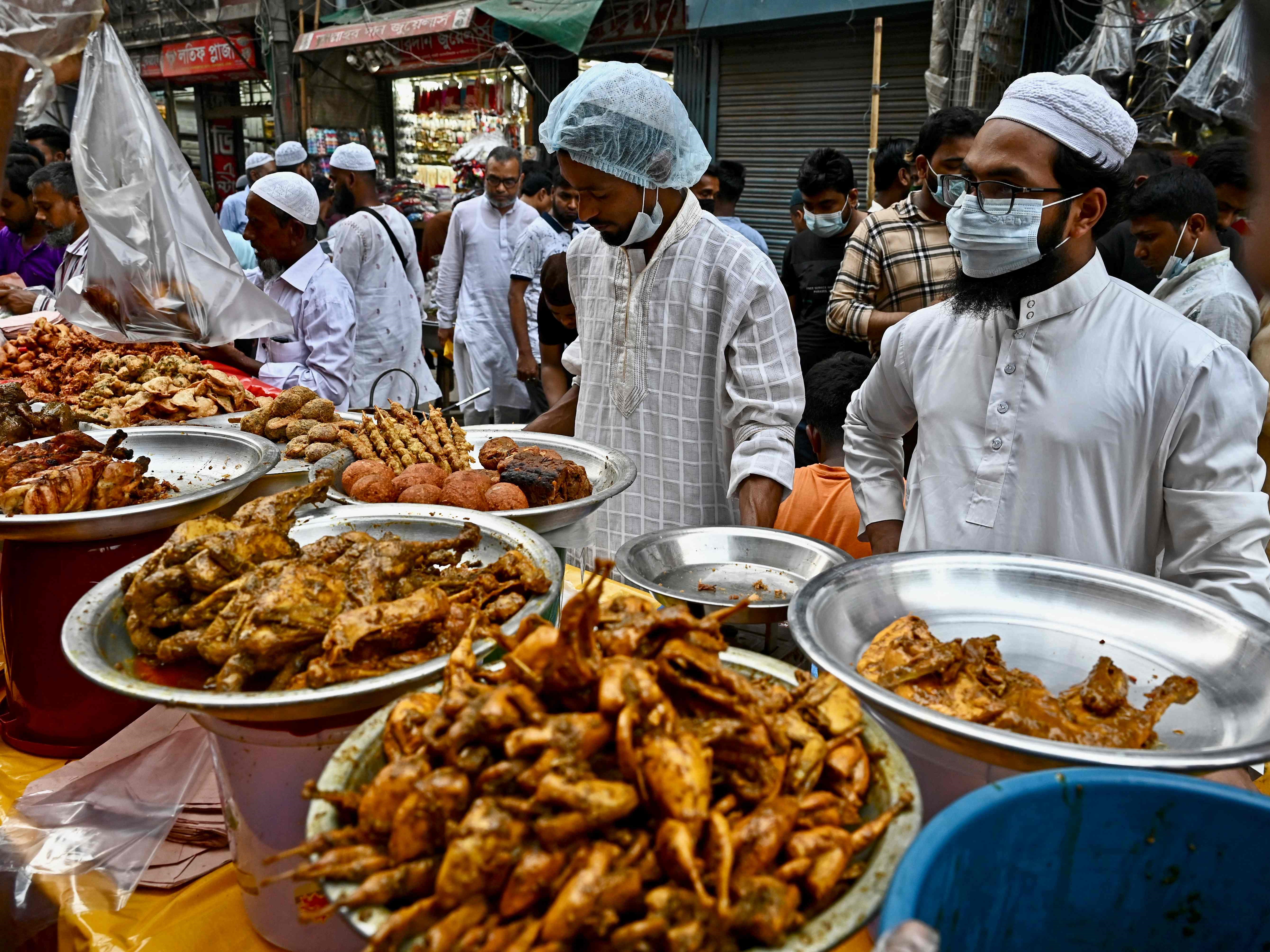 Pedagang kaki lima menunggu pelanggan di sebuah warung makan di pasar pada hari pertama bulan suci Ramadhan di Dhaka.