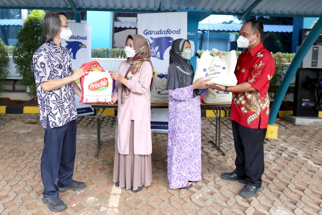 Penyerahan secara simbolis paket sembako murah kepada warga sekitar yang kurang mampu di kantor pusat Garudafood, Jakarta Selatan (19/4).