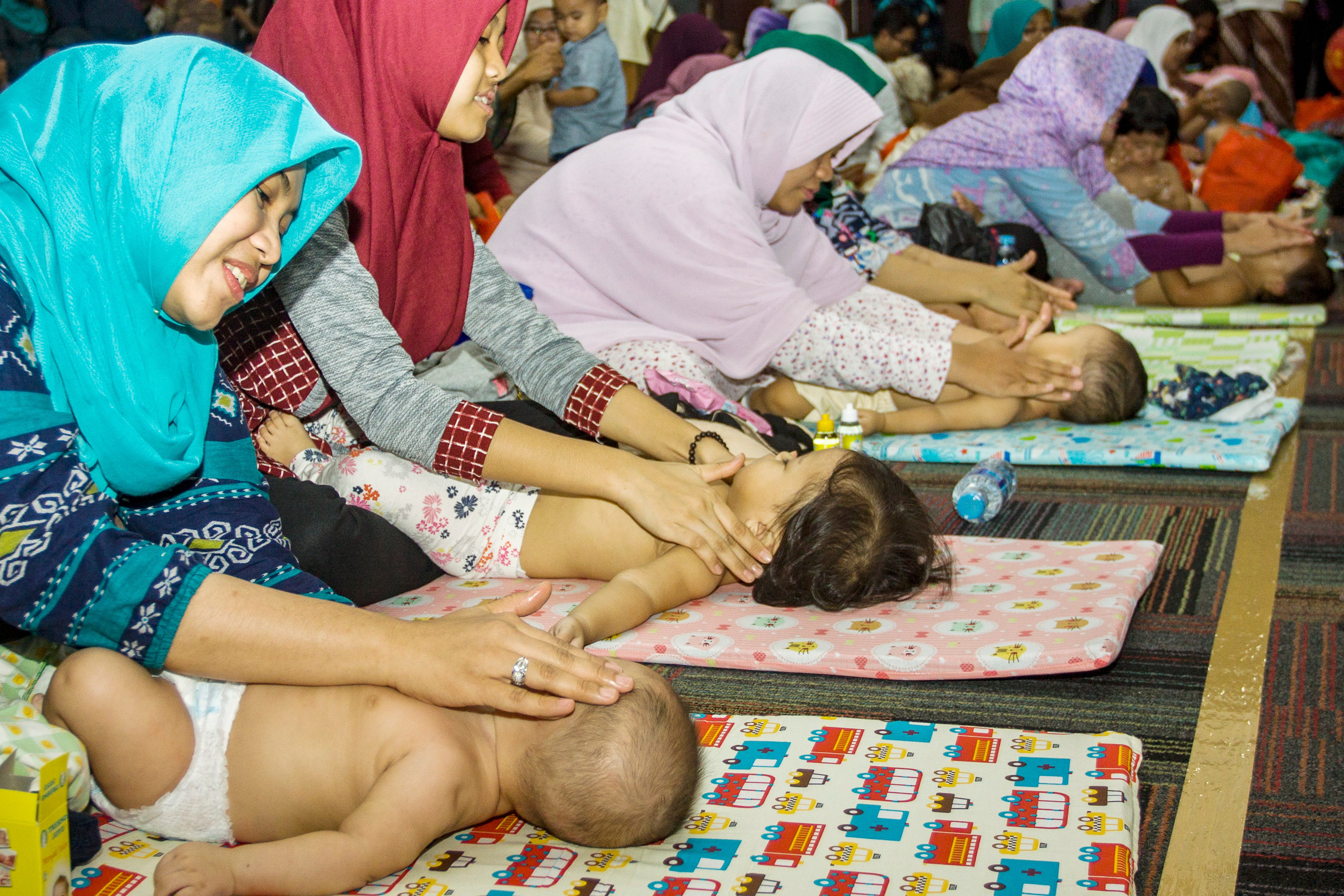 Peserta pijat bayi memijat anaknya saat kegiatan pijat bayi massal di Kementerian Kesehatan, Jakarta, 7 November 2017 lalu.