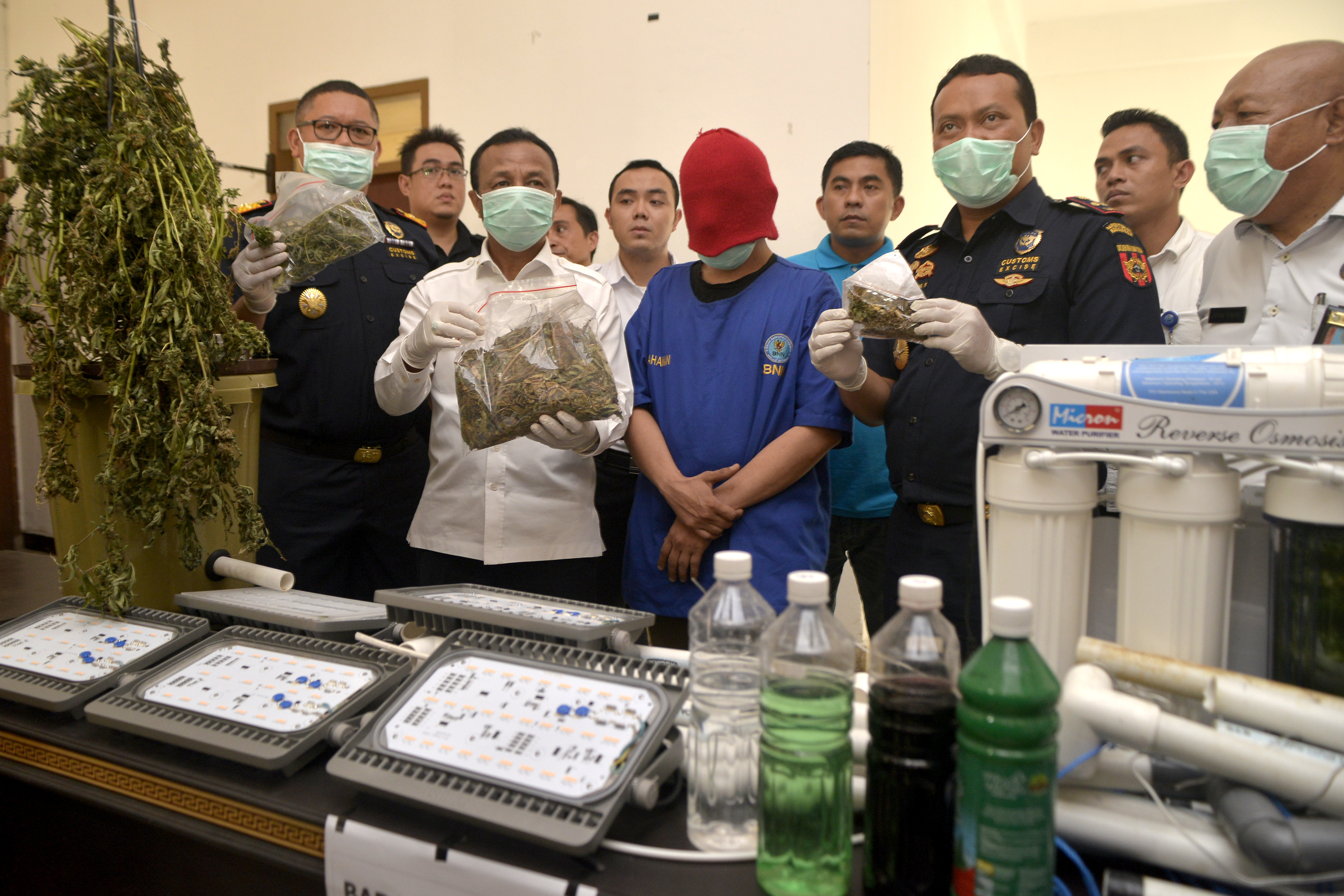 Petugas memperlihatkan seorang pelaku peredaran narkoba di Sulawesi Utara dan barang bukti yang disita