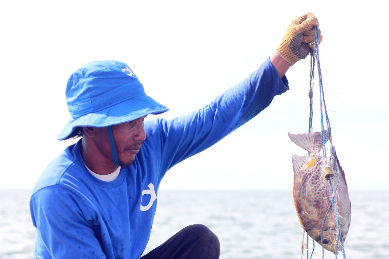 Nelayan memperlihatkan hasil tangkapan ikan yang menjadi produk seafood 