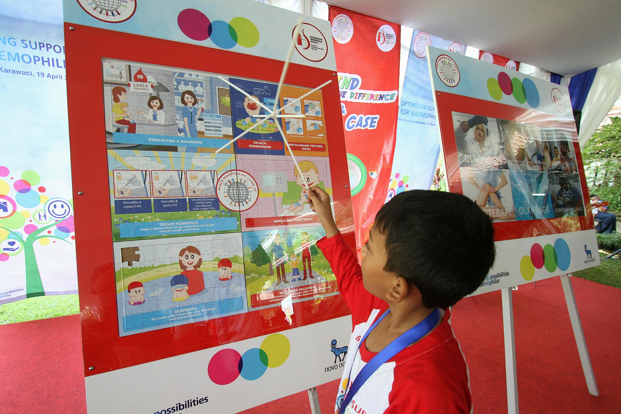 Anak penyandang hemofilia mengamati poster sosialisasi pada peringatan hari hemofilia sedunia di Hotel Aryaduta Karawaci, Tangerang.