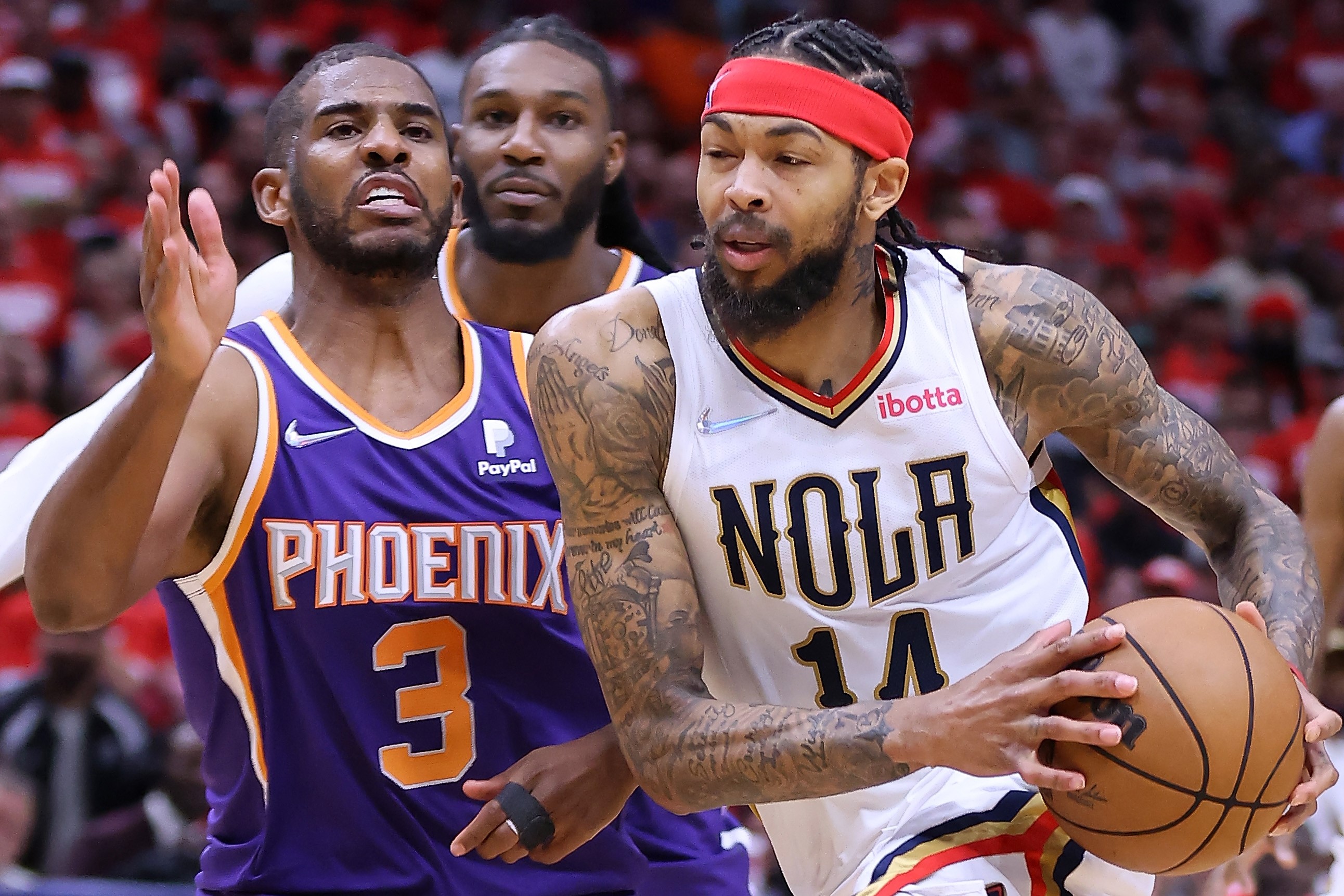 Pemain New Orleans Pelicans Brandon Ingram membawa bola dan Chris Paul dari Phoenix Suns siap merebutnya. 