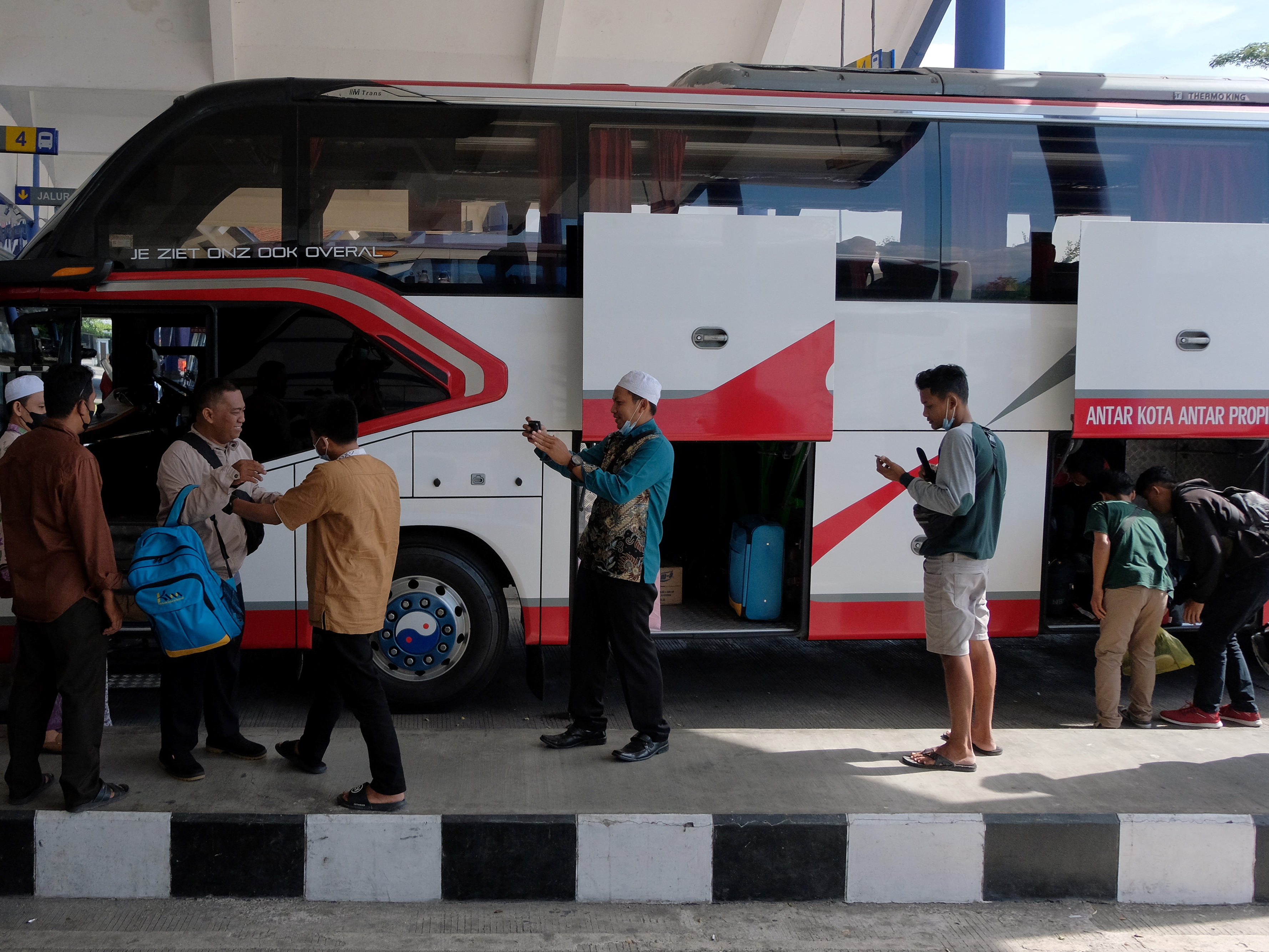 Penumpang bersiap memasuki bus AKAP saat mudik ke kampung halaman di Terminal Mengwi, Badung, Bali, Senin (11/4).