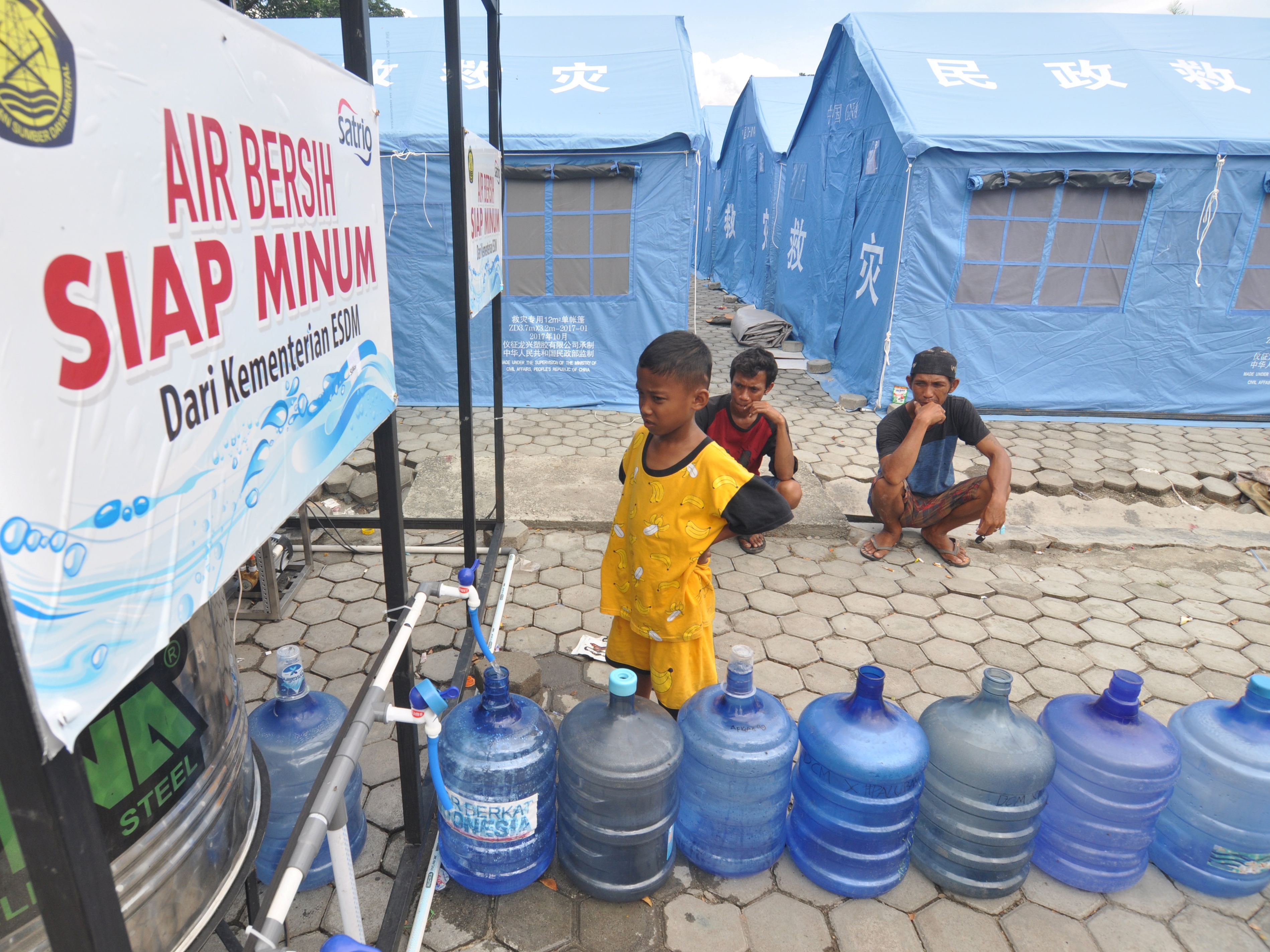 Warga mengisi galon dengan air siap minum bantuan Kementerian ESDM di Palu, Sulawesi Tengah.