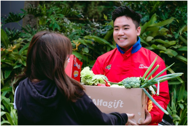 Ilustrasi. Seorang ibu menerima barang belanjaan yang dipesan dari minimarket melalui aplikasi. 