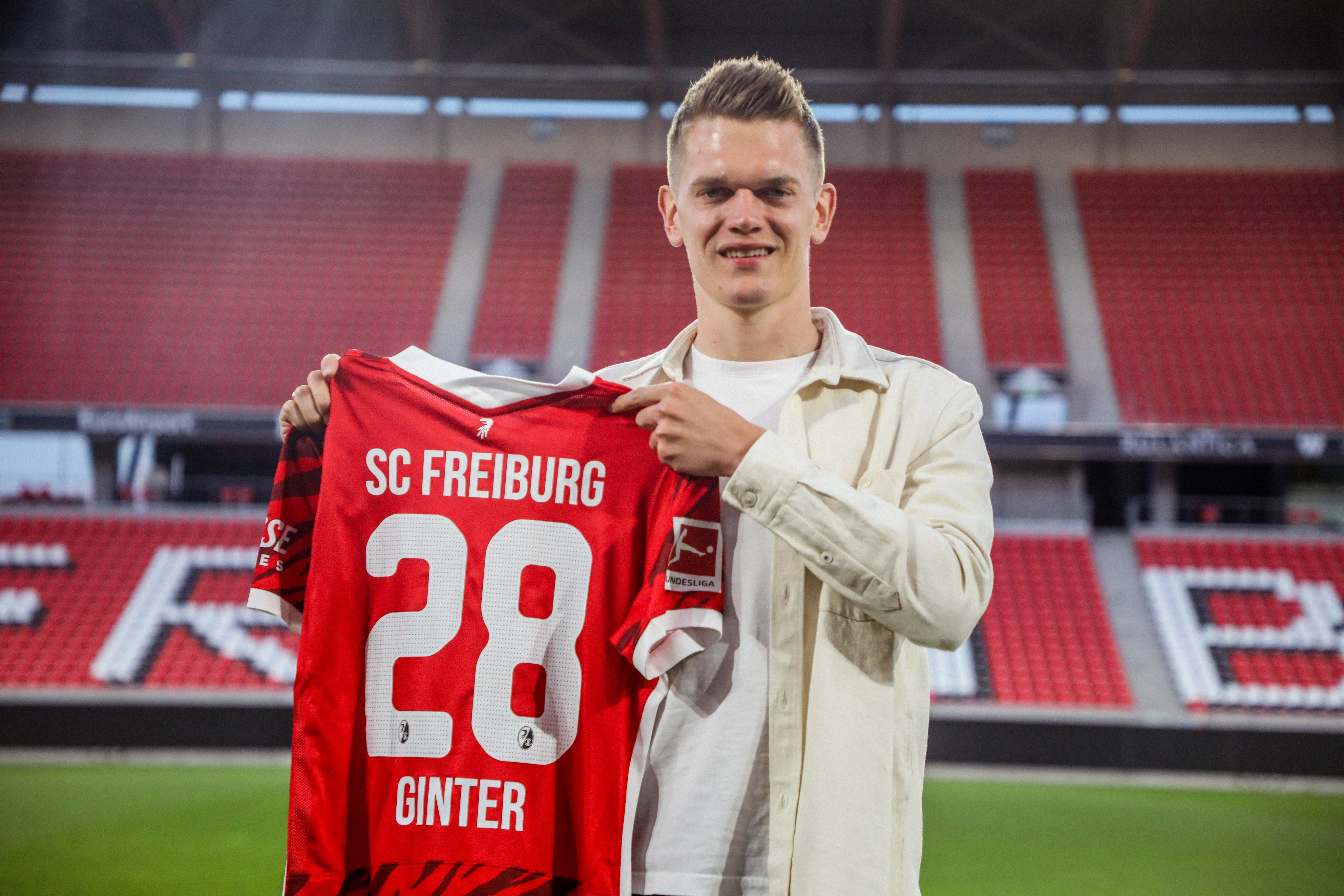 Matthias Ginter memamerkan jersey Freiburg yang akan dikenakannya musim depan.