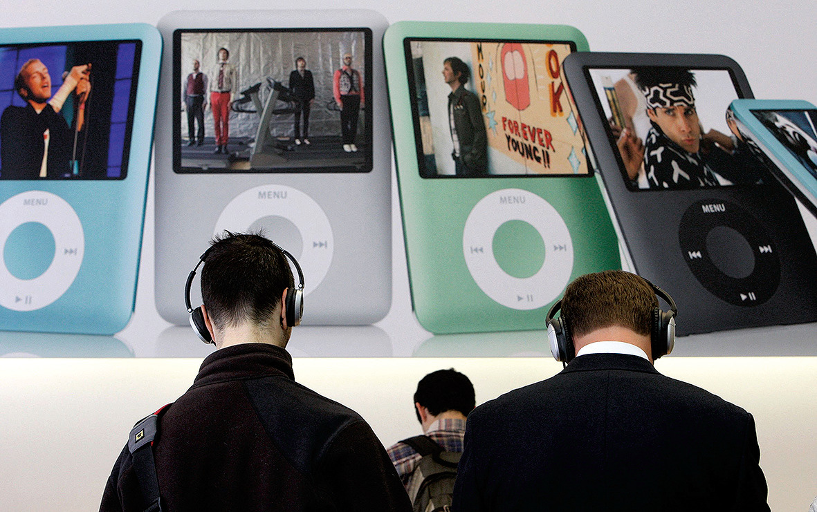 Pelanggan di Apple Store memakai headphone saat mereka mendengarkan Apple iPod nano baru di San Francisco, California.