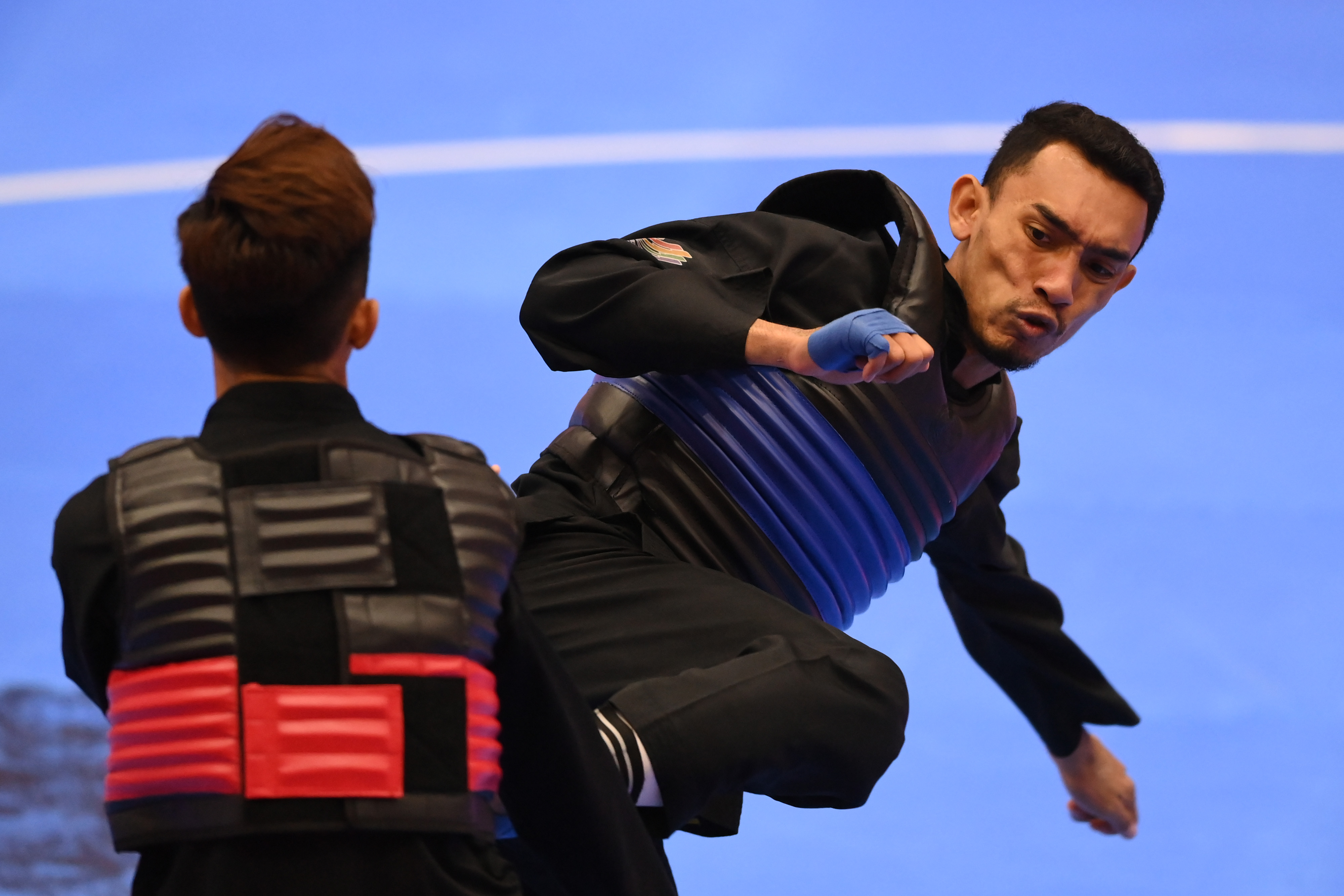Pesilat Indonesia Muhamad Yachser Arafa (kanan) menyerang pesilat Singapura Muhammad Hazim Bin Mohamad Yusli (kiri). 