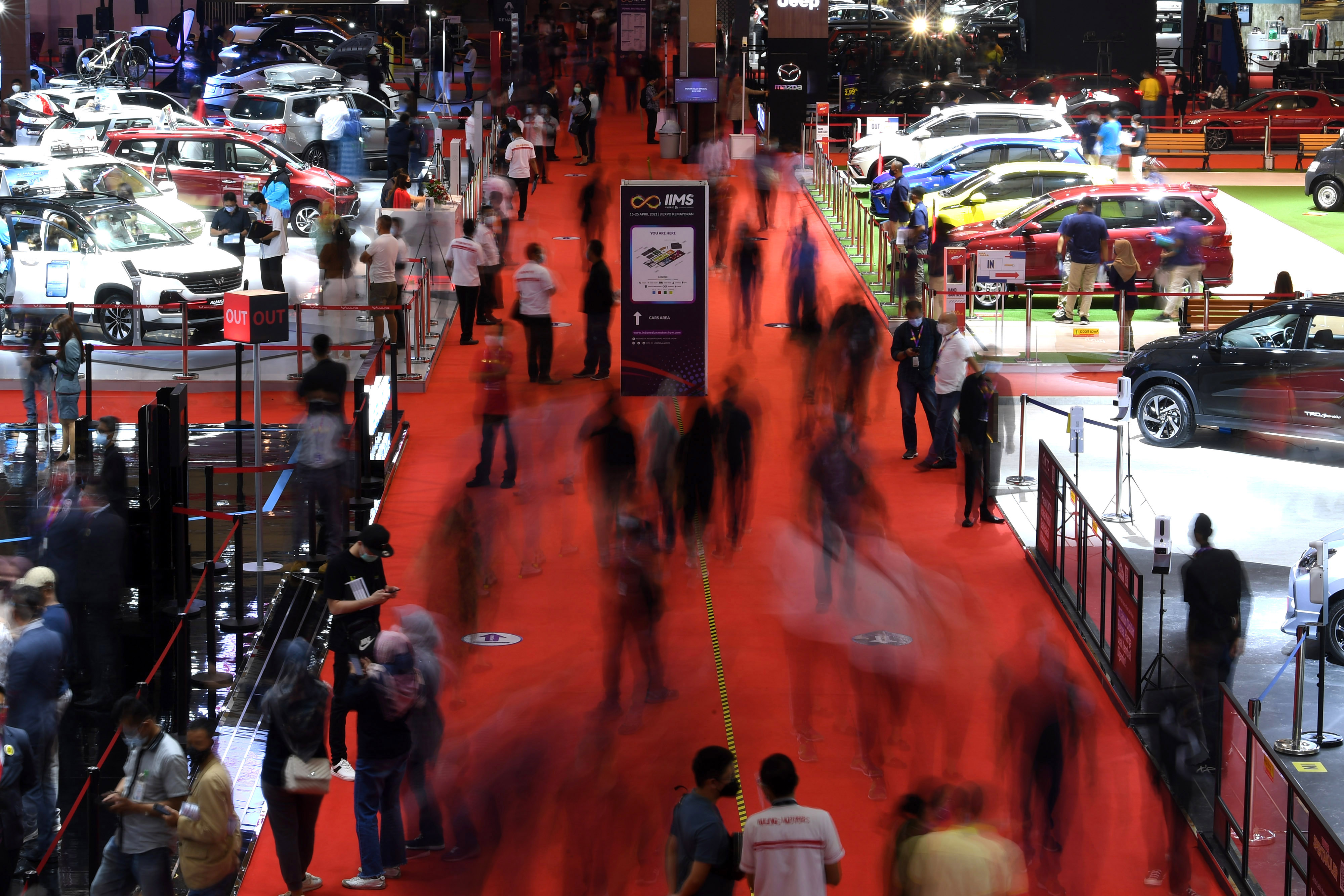 Pengunjung mengamati mobil-mobil yang dipamerkan dalam IIMS Hybrid 2021 di JiExpo Kemayoran, Jakarta, Minggu (18/4/2022).