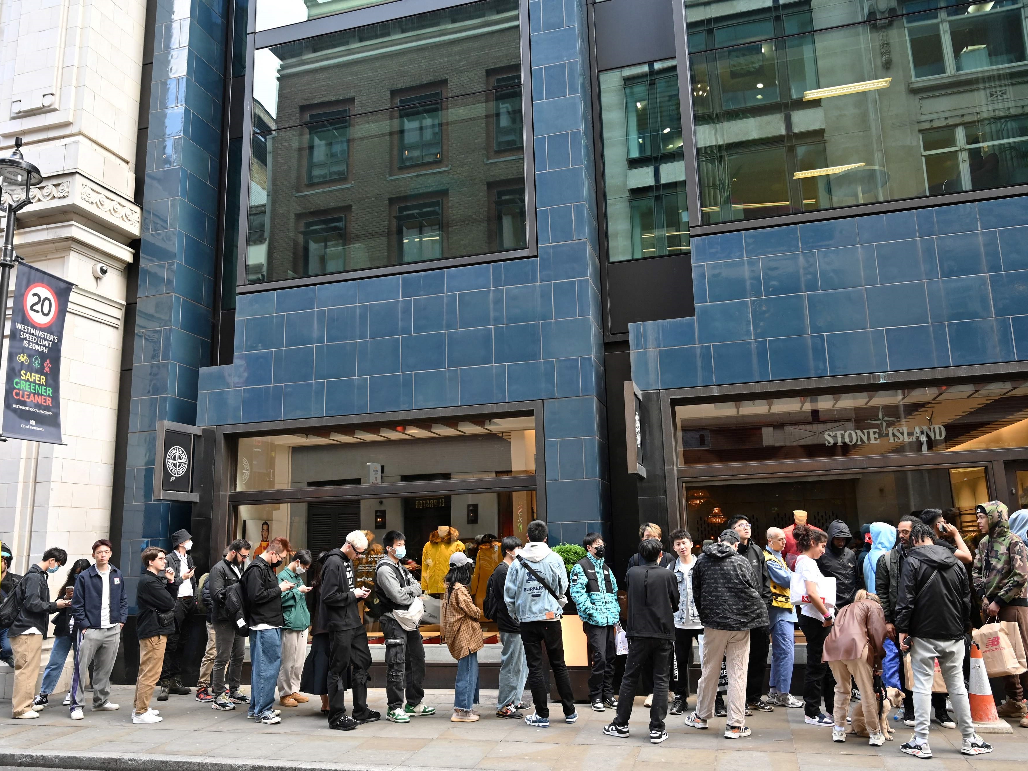 Pelanggan mengantri untuk memasuki toko Stone Island di London pada 12 Mei 2022.