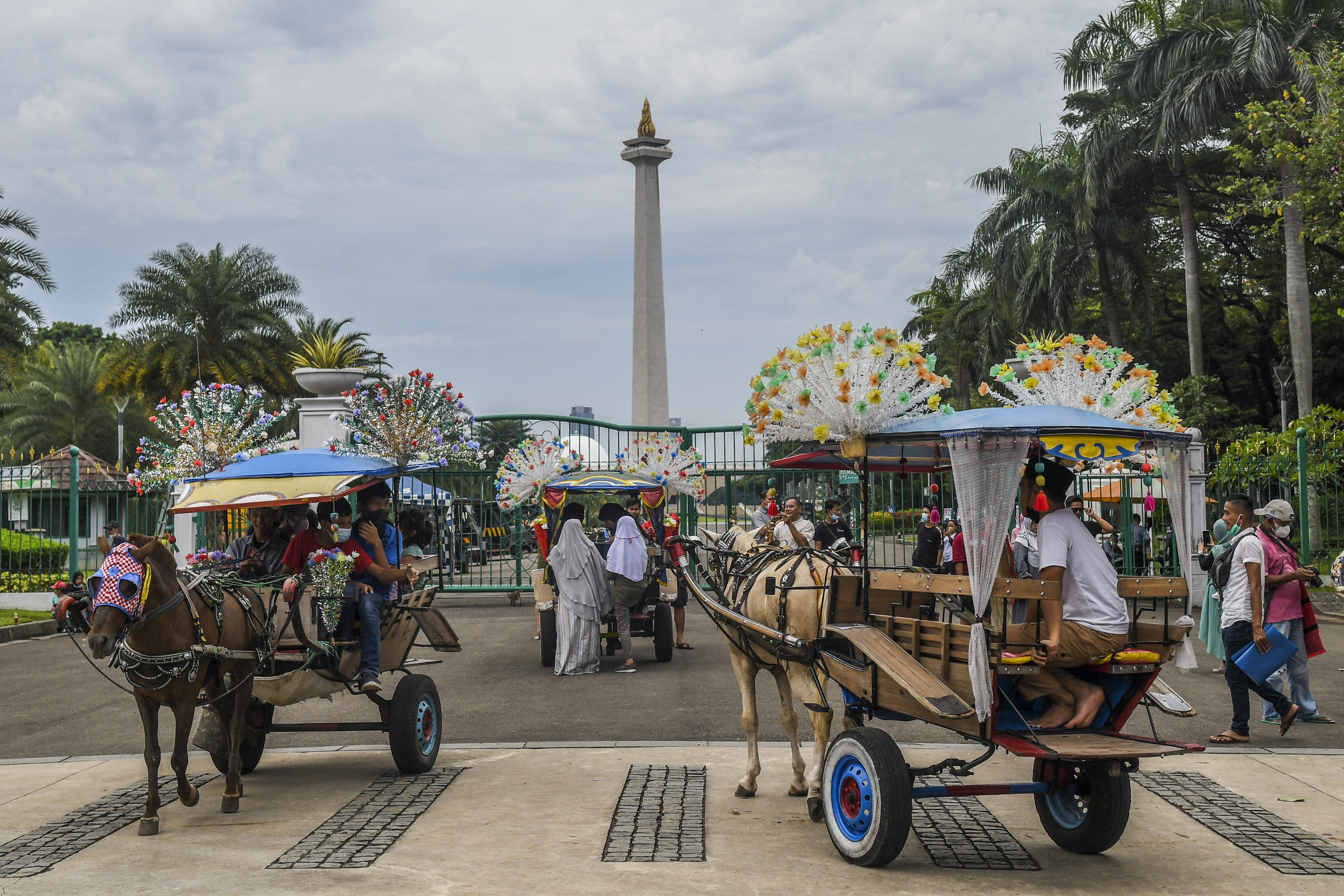 Warga naik delman di kawasan luar Monumen Nasional, Jakarta.