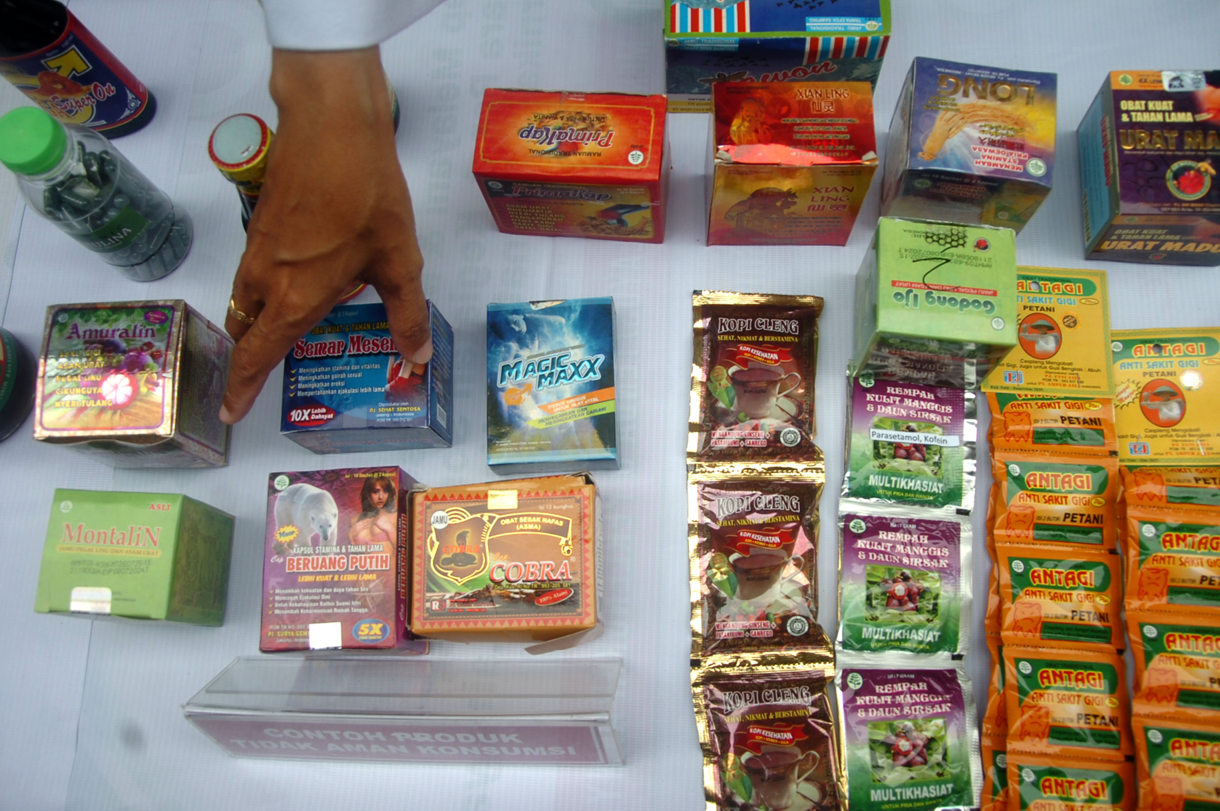  Petugas menunjukkan obat tidak layak edar saat sosialisasi waspada obat tradisional mengandung bahan kimia dan kosmetik tanpa izin.