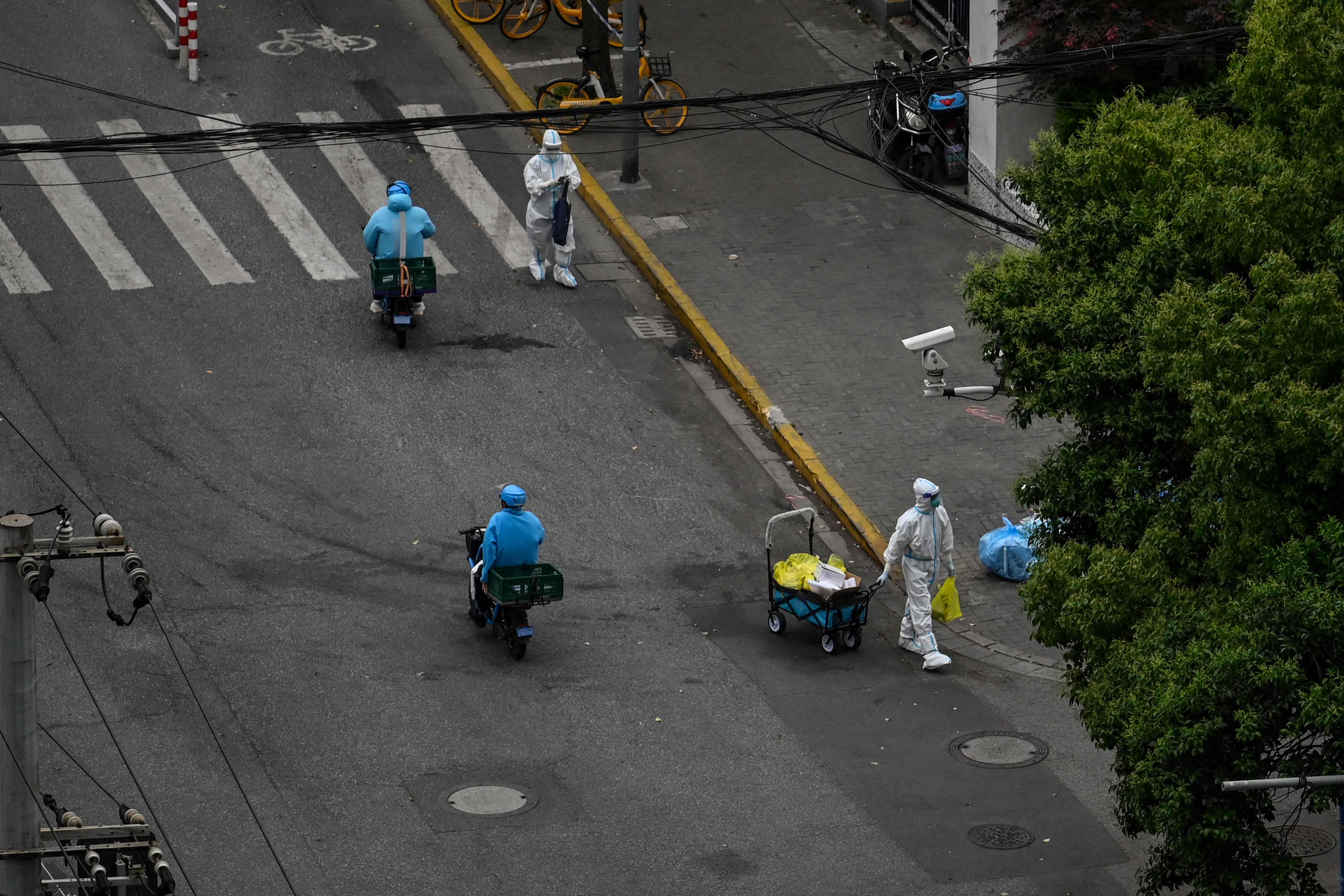 Petugas medis dengan mengenakan pelindung diri bekerja di Distrik Jing'an, Shanghai, Tiongkok, yang menerapkan 'lockdown', Senin (9/5). 