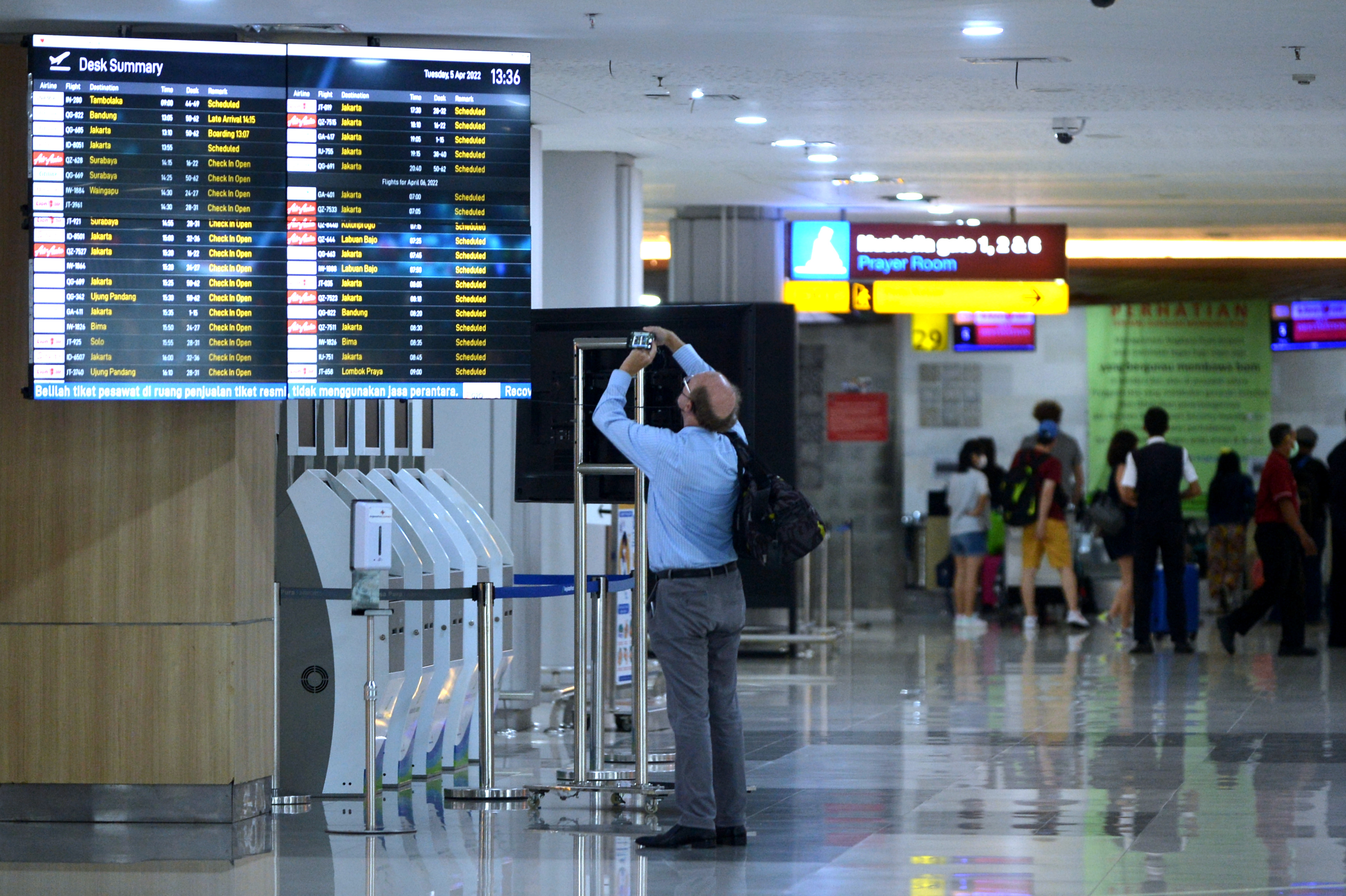  Calon penumpang pesawat melihat jadwal penerbangan di Terminal Domestik Bandara Internasional I Gusti Ngurah Rai, Badung, Bali.