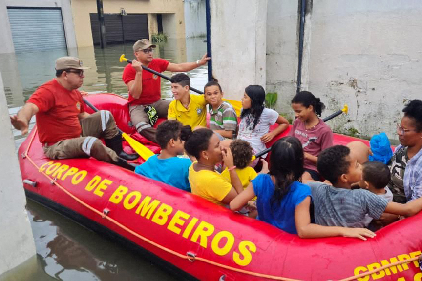 Petugas pemadam kebakaran mengevakuasi penduduk dari daerah banjir di Recife, negara bagian Pernambuco, Brasil, pada 28 Mei 2022.
