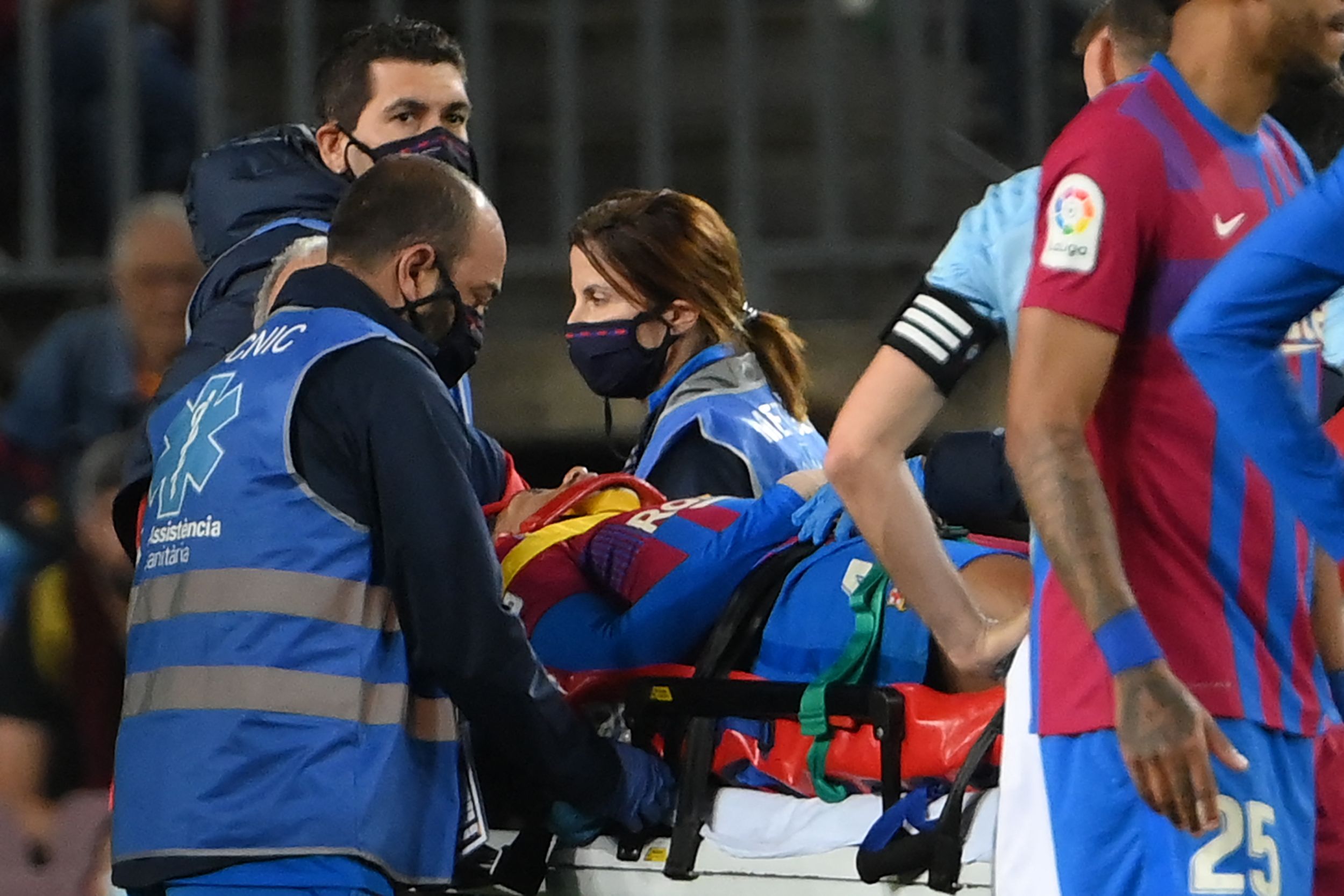 Bek Barcelona Ronald Araujo diangkut menggunakan tandu ke ambulans yang akan membawanya ke rumah sakit.