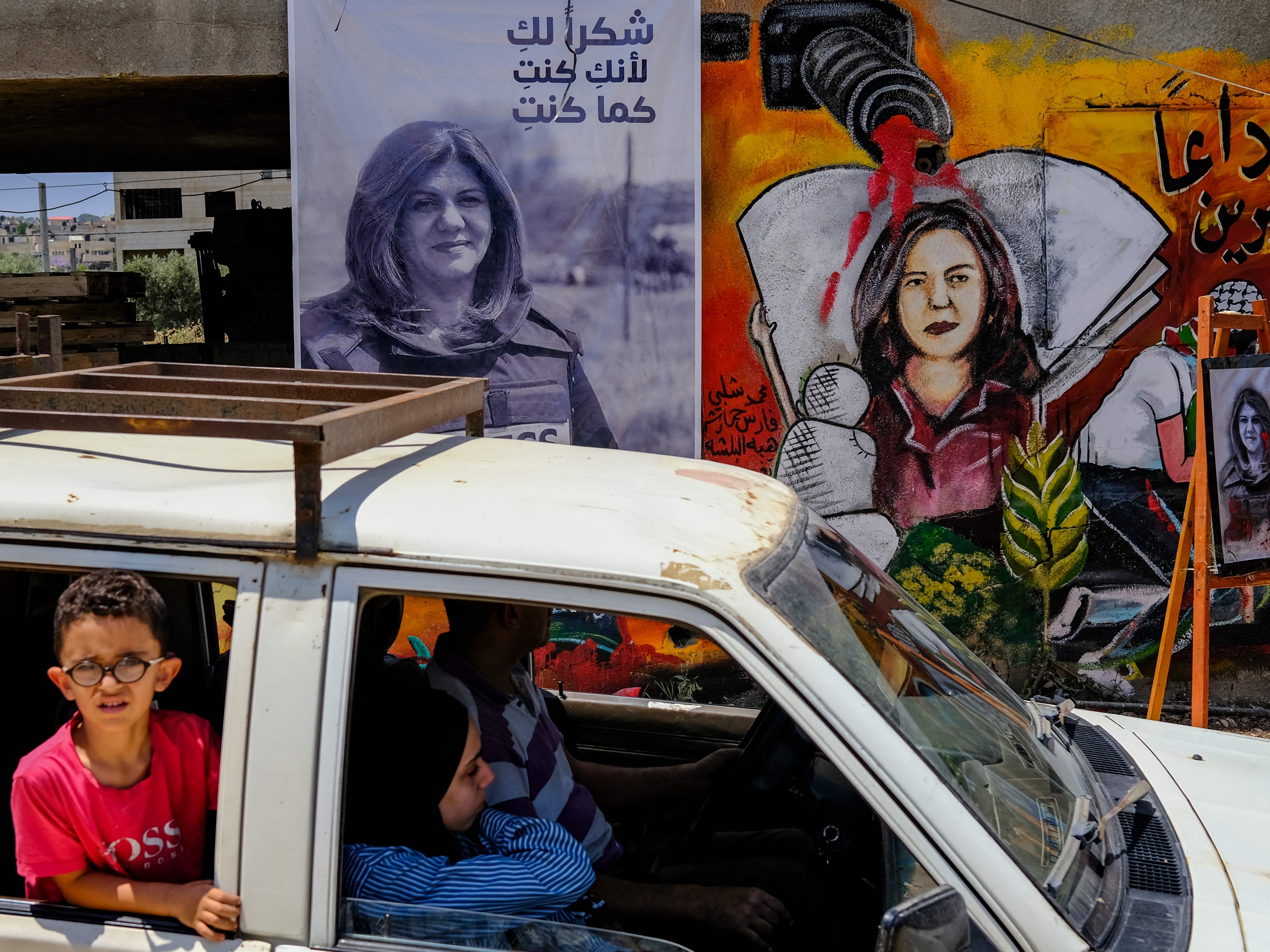 Keluarga melintas di depan pameran seni untuk menghormati mendiang jurnalis Al-Jazeera Palestina Shireen Abu Akleh di kota Jenin.