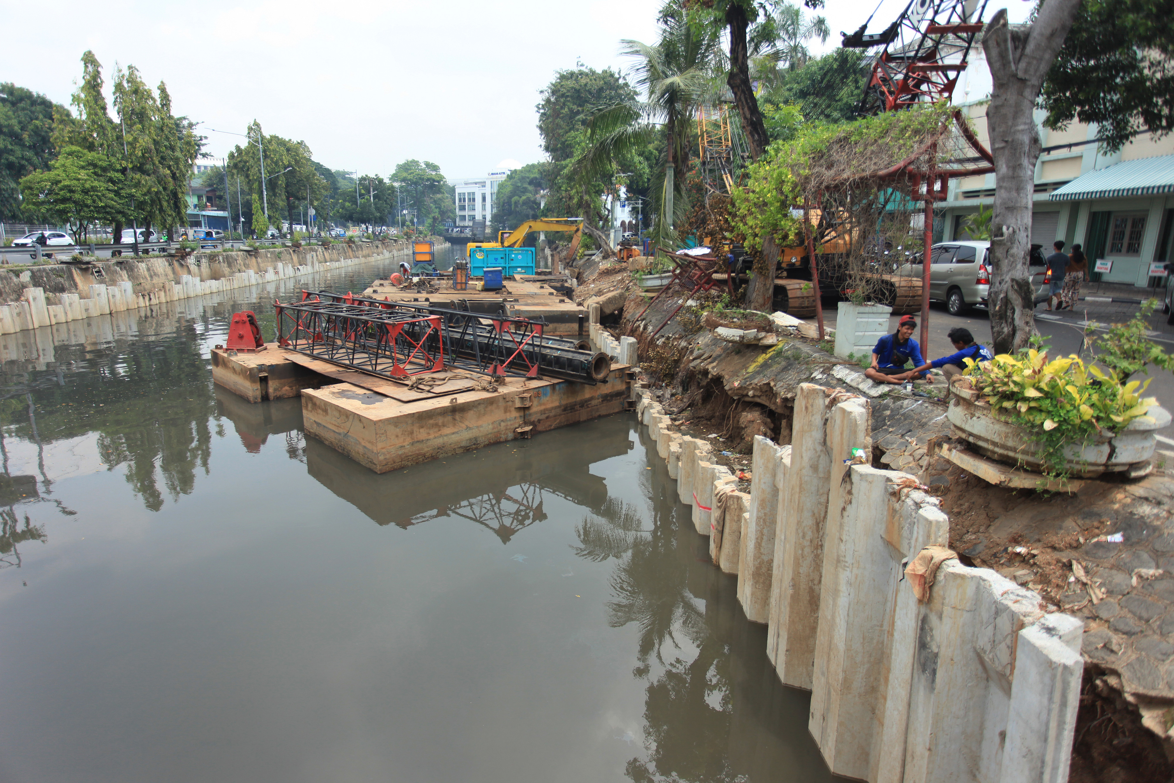 Pekerja dengan menggunakan alat berat tengah membangun turap Anak Kali Ciliwung di kawasan Pasar Baru, Jakarta Pusat, Selasa (5/4/2022). 